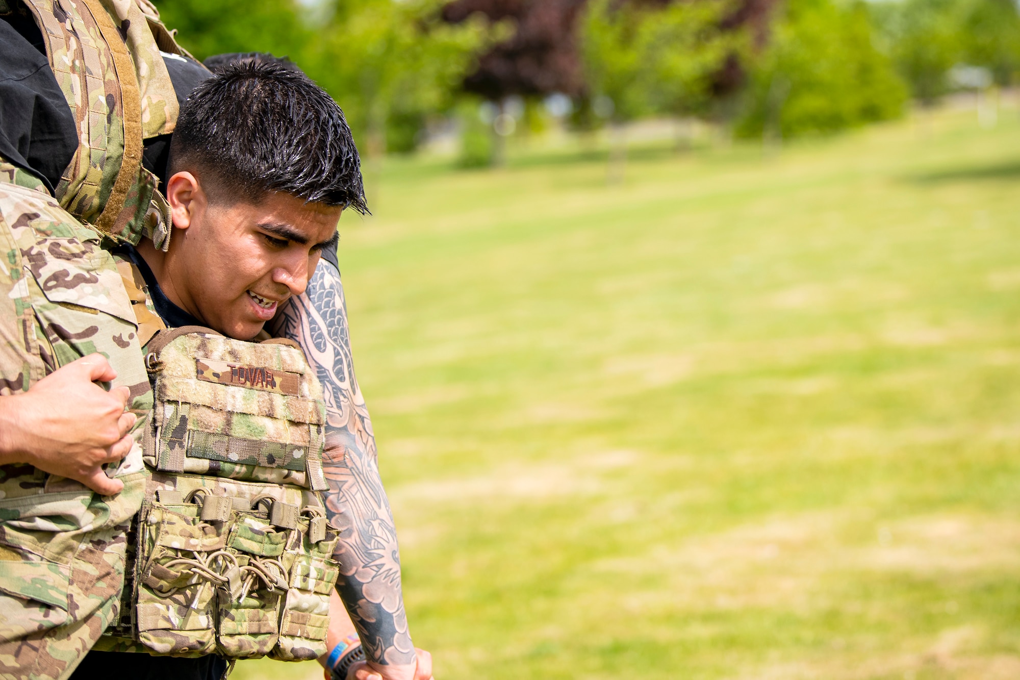 U.S. Air Force Senior Airman Adrien Tovar, 423d Security Forces Squadron trainer, carries Staff Sgt. Noel Rillona, 423d Security Forces Squadron flight trainer, during a defender challenge at RAF Alconbury, May 18, 2022. Airmen, civilians and local law enforcement participated in the challenge, held in honor of National Police Week, to pay homage to those who gave their lives in the line of duty. (U.S. Air Force photo by Staff Sgt. Eugene Oliver)