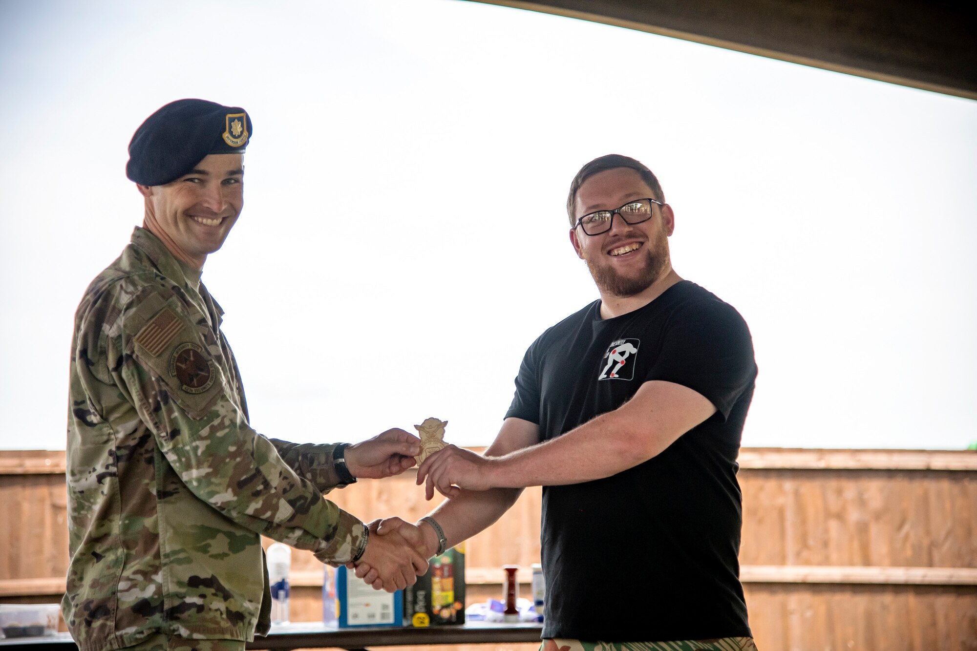 U.S. Air Force Major Daniel Merkh, left, 423d Security Forces Squadron commander, awards Luke Young, 423d SFS resource protection program manager, following a defender challenge at RAF Alconbury, England, May 18, 2022. Airmen, civilians and local law enforcement participated in the challenge, held in honor of National Police Week, to pay homage to those who gave their lives in the line of duty. (U.S. Air Force photo by Staff Sgt. Eugene Oliver)
