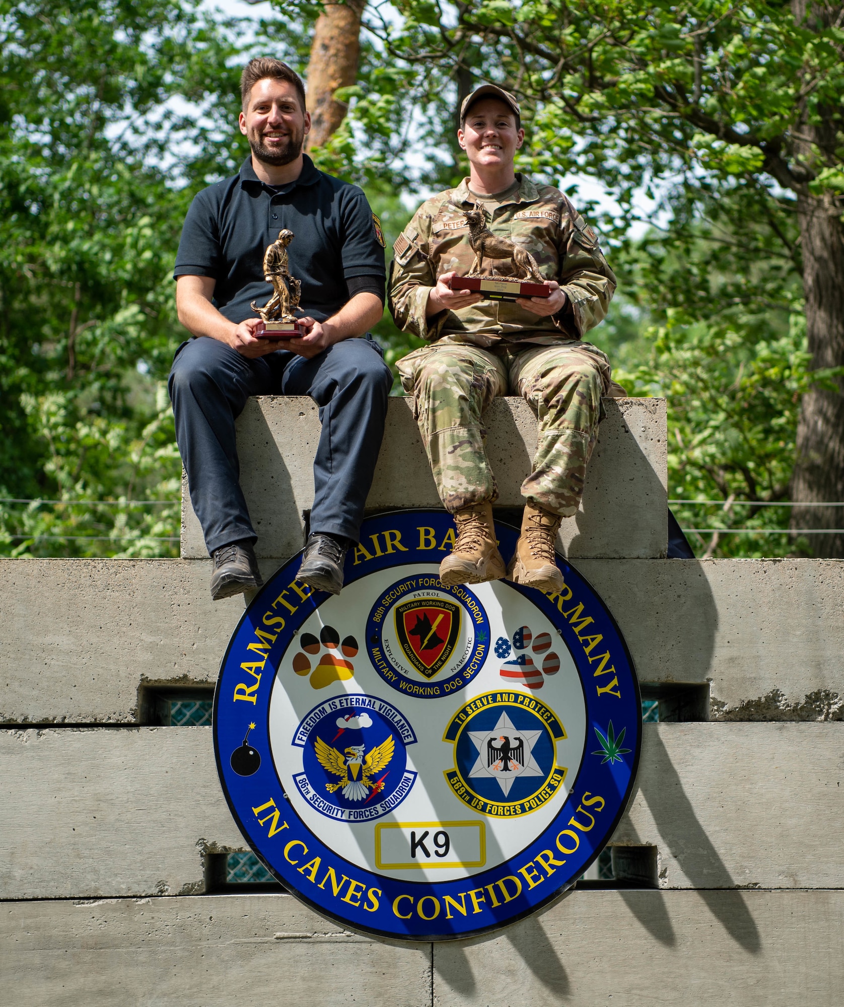 German Polizei Officer Andreas Goldinger, K-9 handler and his K-9 partner, Coco, take home the Patrol award and U.S. Air Force Staff Sgt. Britney Peters, 86th Security Force Squadron Military Working Dog handler and her K-9 partner, Paik, take home the Iron Dog award presented at the 86th Security Forces 2022 Military Working Dog Competition, at Ramstein Air Base, Germany, May 19, 2022.