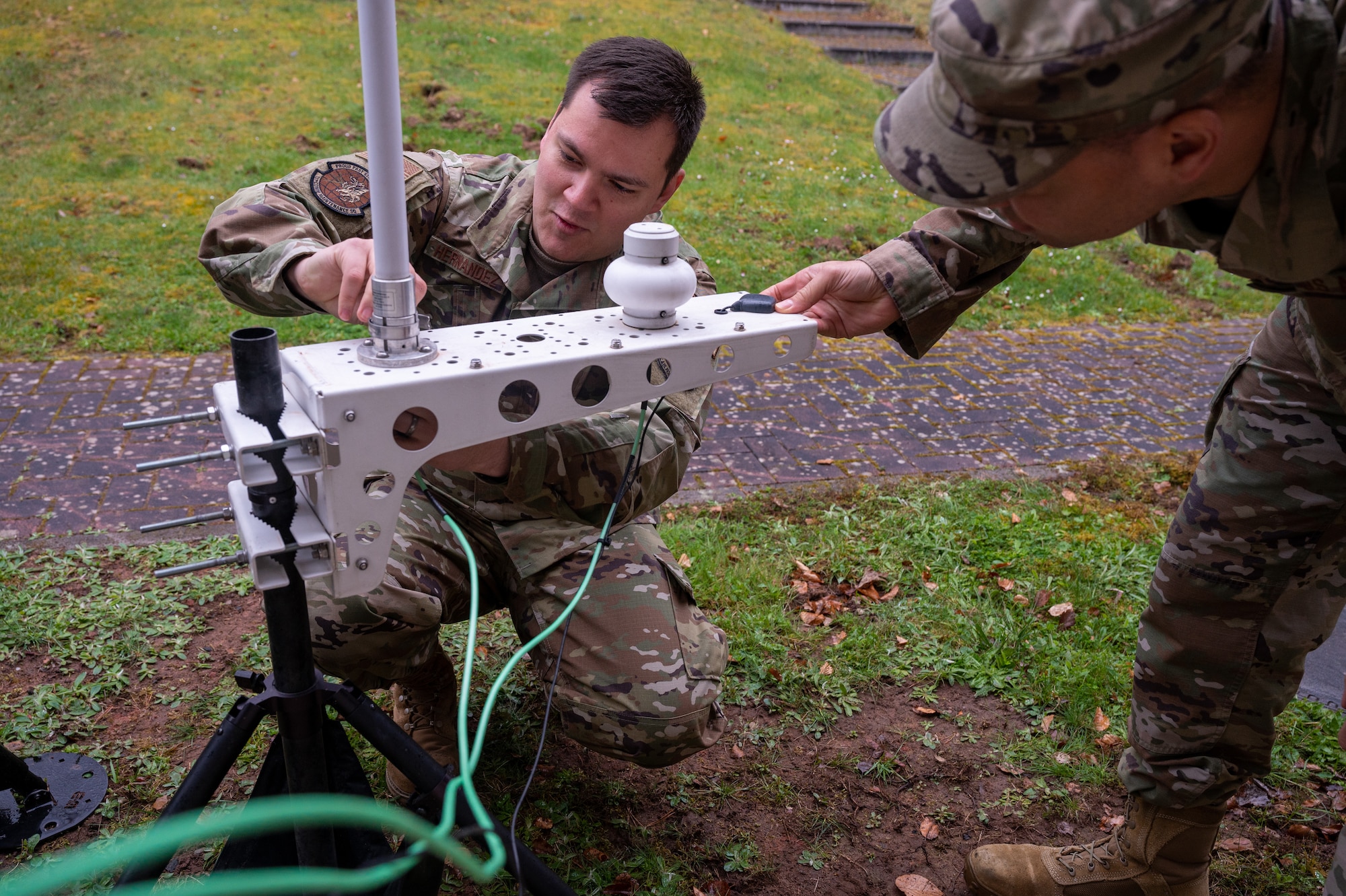 Two Airmen working on communications equipment.