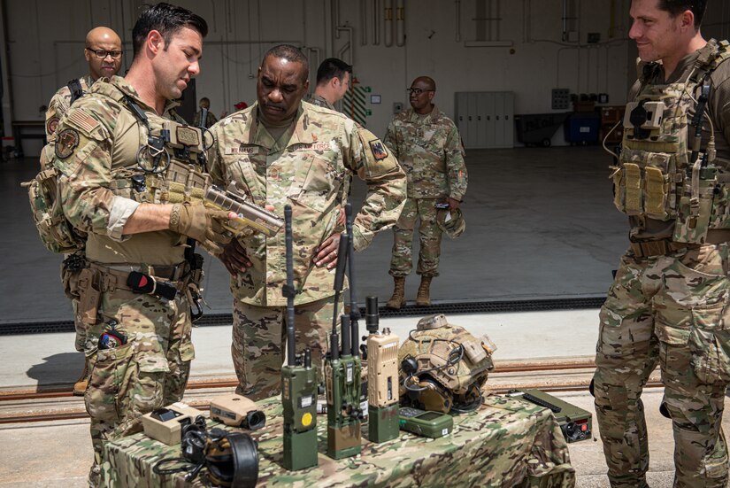 U.S. Air Force Chief Master Sergeant Maurice L. Williams, command chief, Air National Guard, center, listens to Tech. Sgt. Zachary Holden, Tactical Air Control Party, 148th Air Support Operations Squadron, left, as he describes the hand laser marker to the chief as Senior Amn. Alex Lyons looks on during Williams' visit to the 193rd Special Operations Wing, Harrisburg International Airport, Middletown, Pennsylvania, May 15, 2022. While visiting, Williams toured squadrons and spoke to Airmen on the importance of professional development, Airman leadership and mentorship.