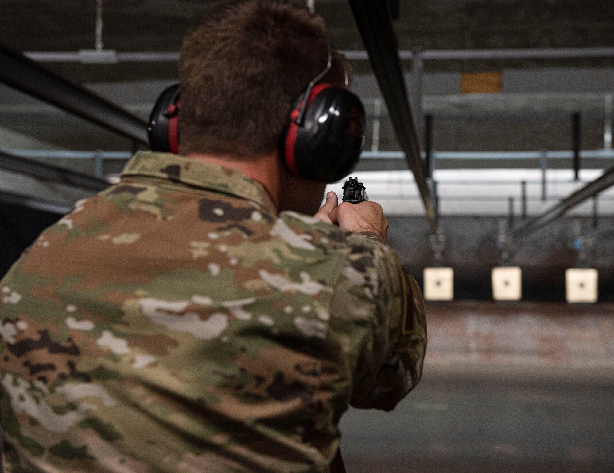 An Airman assigned to the 4th Fighter Wing shoots a pistol at a target during a pistol match held in honor of National Police Week at Seymour Johnson Air Force Base, North Carolina, May 19, 2022. The pistol match competition had time constraints for those who participated, which made it essential for competitors to be fast and effective to gain points. (U.S. Air Force photo by Airman 1st Class Sabrina Fuller)