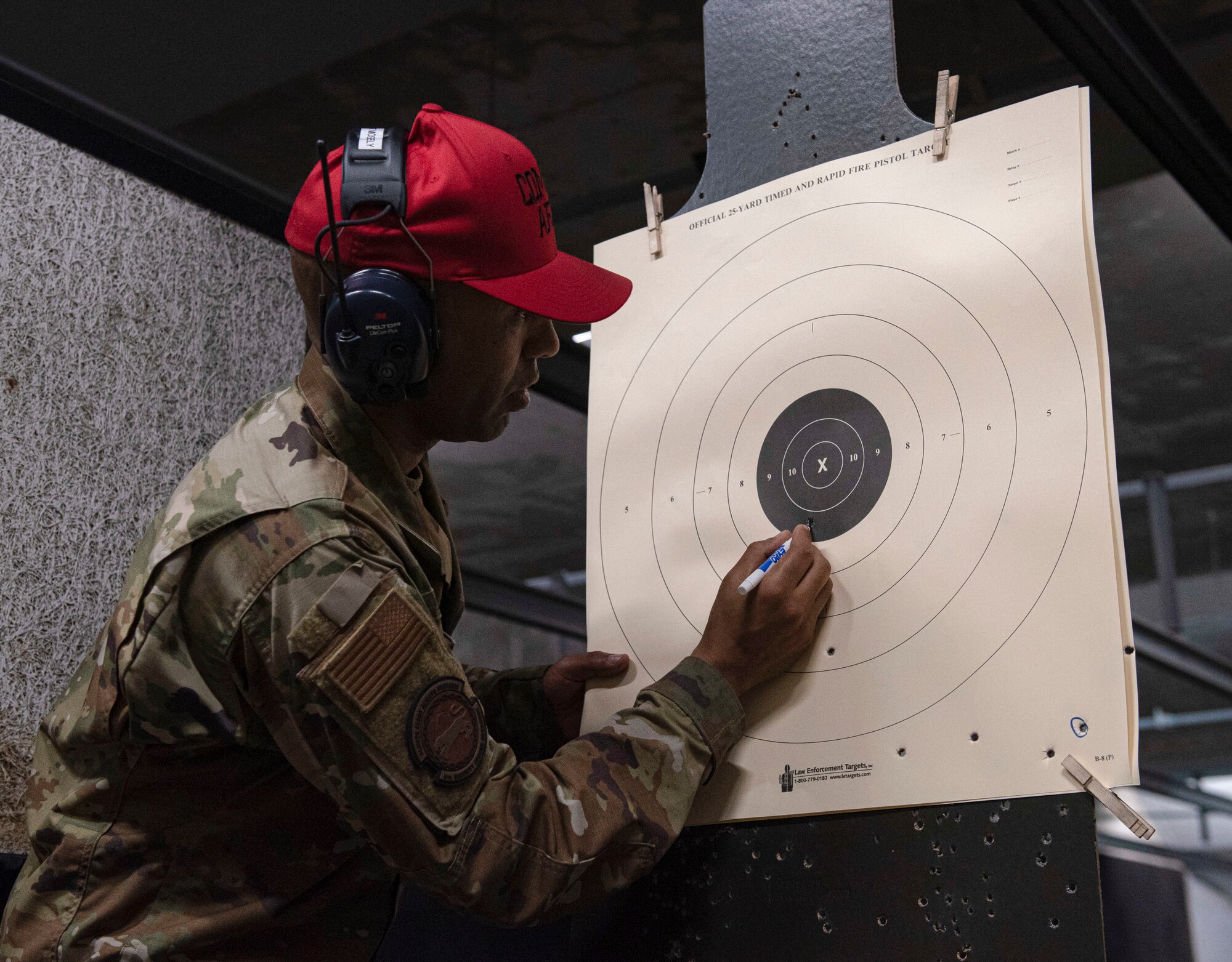 Staff Sgt. Thomas Mosely, 4th Security Forces Squadron combat arms instructor, checks the score sheet of a participant of a pistol match in honor of National Police Week at Seymour Johnson Air Force Base, North Carolina, May 19, 2022. The pistol match competition was open to all base personnel to participate in. (U.S. Air Force photo by Airman 1st Class Sabrina Fuller)