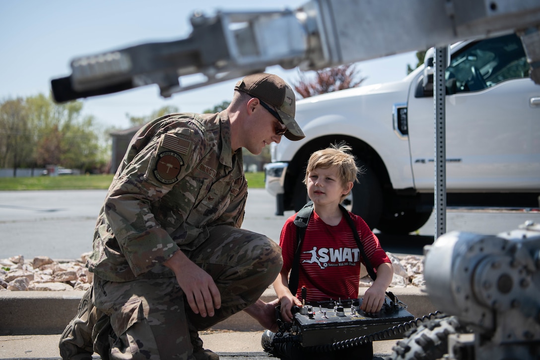 An airman and his son use a control panel.