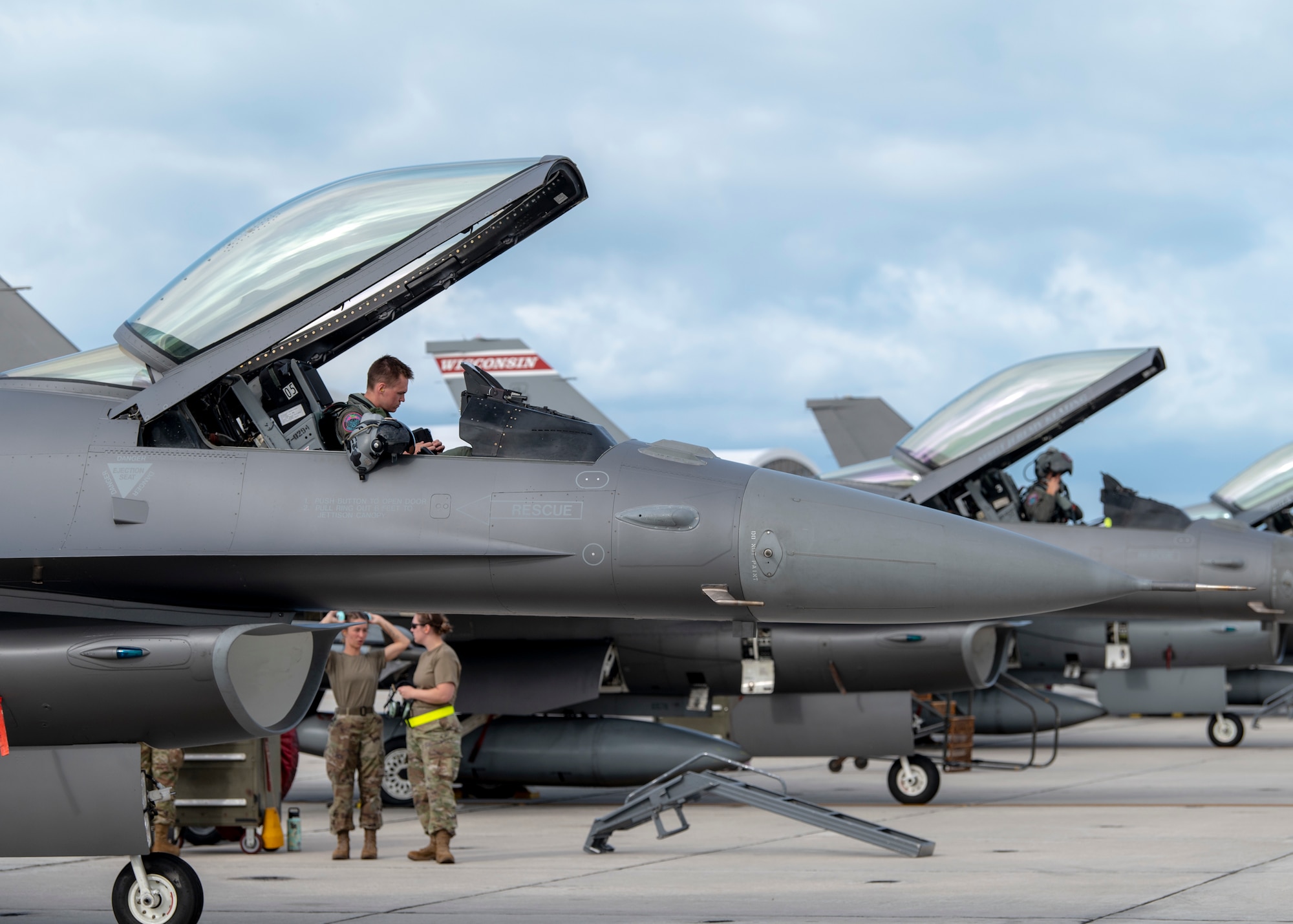 Pilots sit in F-16 Fighting Falcon aircraft in preparation for take off.