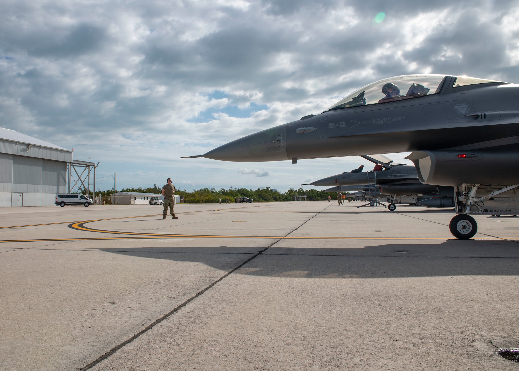 An Airmen marshalls an F-16 Fighting Falcon aircraft