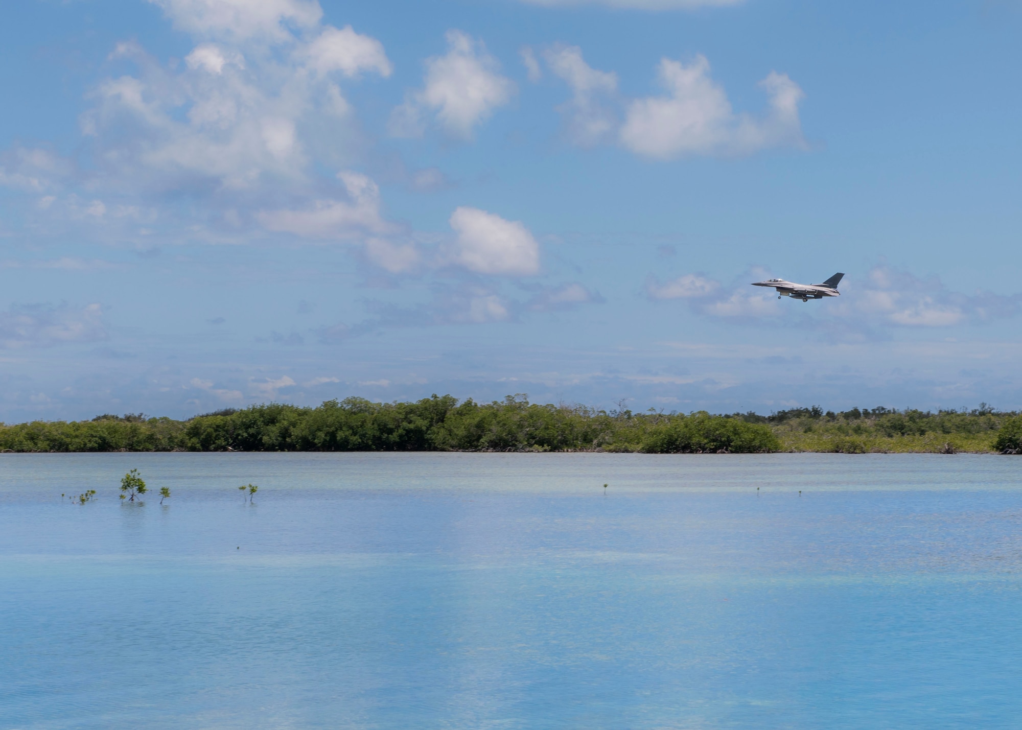 An F-16 Fighting Falcon aircraft flies the landing leg over the ocean at NAS Key West