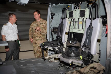 Chief Warrant Officer 3 Adam Truso, a UH-60 Black Hawk pilot with C Company, 3-126th Aviation Regiment (Air Ambulance), Vermont Army National Guard, shows Austrian service members around the Army Aviation Support Facility in South Burlington, Vermont, during a tour May 12, 2022. The Vermont National Guard and Austrian Defence Ministry signed a State Partnership Program agreement May 11, 2022, to strengthen interagency cooperation and mutually improve in cyber defense, information operations, military mountaineering, humanitarian and disaster assistance response, and other areas. (U.S. Army National Guard photo by Don Branum)