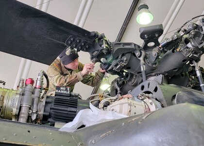 U.S. Army Spc. Tyler Martin, a UH-60 Black Hawk helicopter repairer with Delta Company, 2nd Battalion, 224th Aviation Regiment, 29th Infantry Division, Virginia National Guard, conducts maintenance on a Black Hawk at Camp Bondsteel, Kosovo, March 18, 2022.