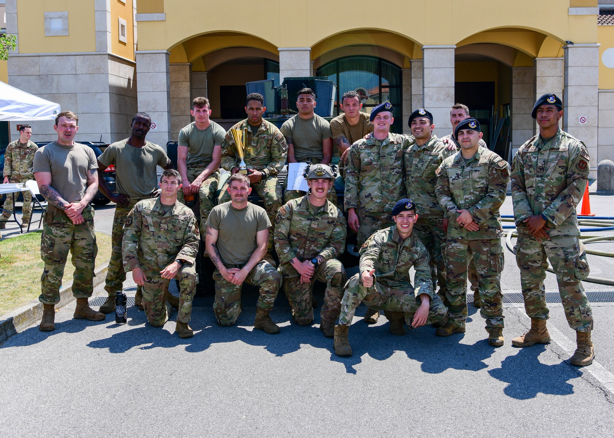 U.S. Air Force Airmen assigned to the 31st Security Forces Squadron and 31st Civil Engineer Squadron Fire Department pose for a photo after competing in the annual Police Week Guns and Hoses competition at Aviano Air Base, Italy, May 18, 2022. The competition consisted of an obstacle course where three 31st SFS teams competed against one 31st CES Fire Department team in challenges themed after their respective jobs. In 1962, President Kennedy declared Peace Officers Memorial Day to be observed on May 15 and recognized May 15 as National Police Week. (U.S Air Force photo by Senior Airman Brooke Moeder)