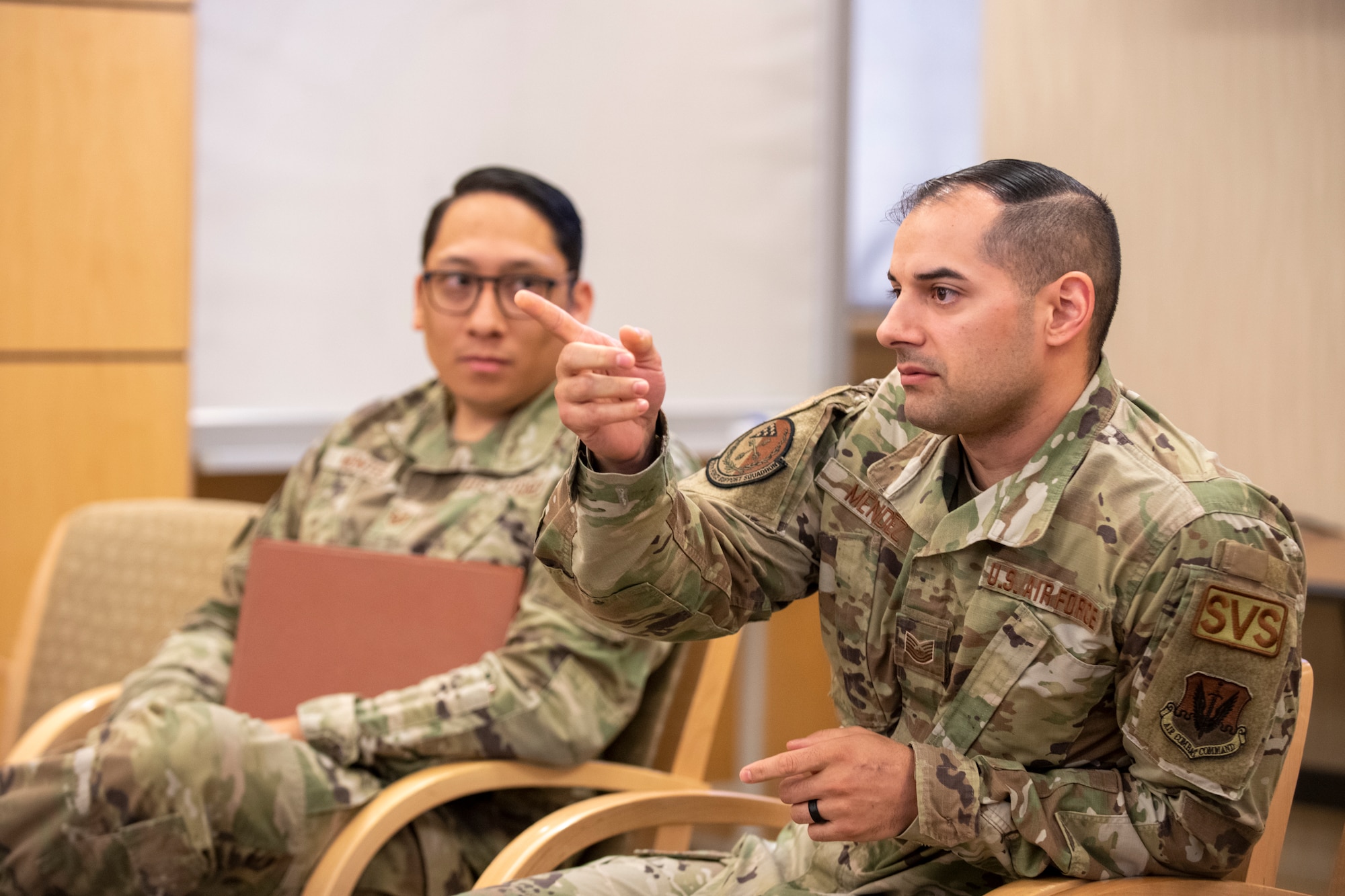 Man in uniform points as he talks