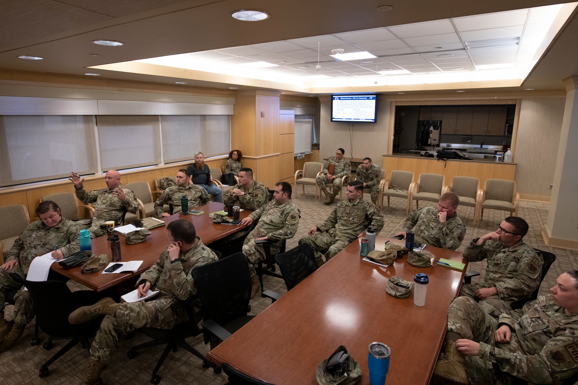 Group of service members gathered at tables talk.