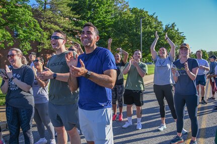 Participants at the 5K Memorial Ruck cheer as people cross the finish line at Joint Base Andrews, Md., May 17, 2022. The ruck, held in memory of fallen law enforcement officers, was added to the schedule of events during National Police Week in an effort to improve the mental, physical, social and spiritual resilience among service members and their families. (U.S. Air Force photo by Airman 1st Class Isabelle Churchill)