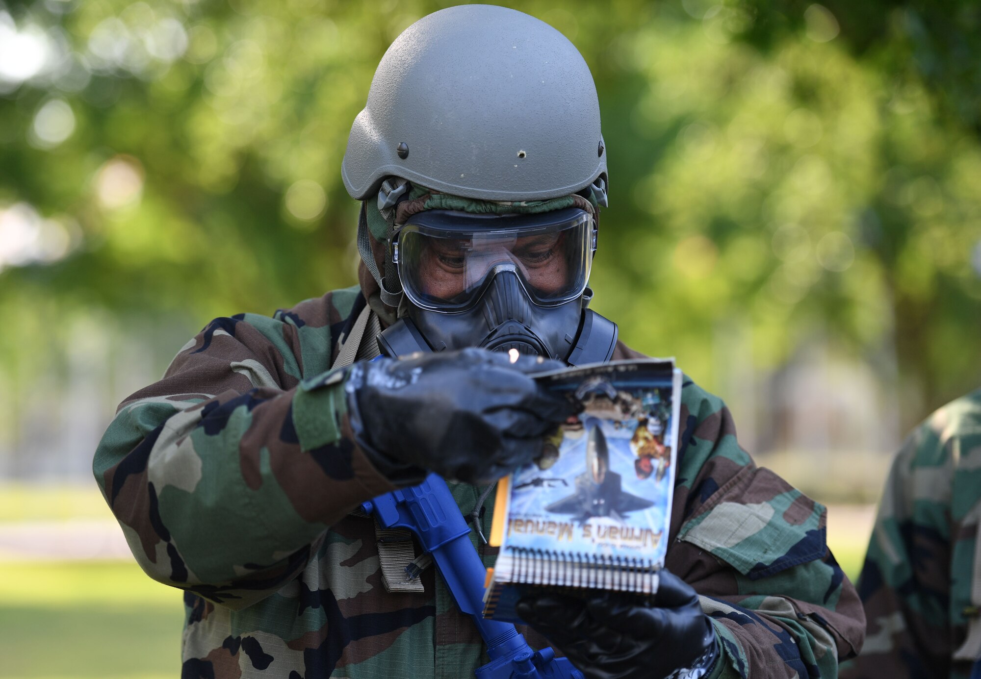 U.S. Air Force Tech. Sgt. Ramiro Gonzalez, 81st Force Support Squadron manpower analyst, reviews the Airman's manual to help identify a chemical agent during a small scale readiness assessment at Keesler Air Force Base, Mississippi, May 18, 2022. The assessment allowed Keesler personnel to be evaluated on their basic life saving skills in preparation of real-world events. (U.S. Air Force photo by Kemberly Groue)