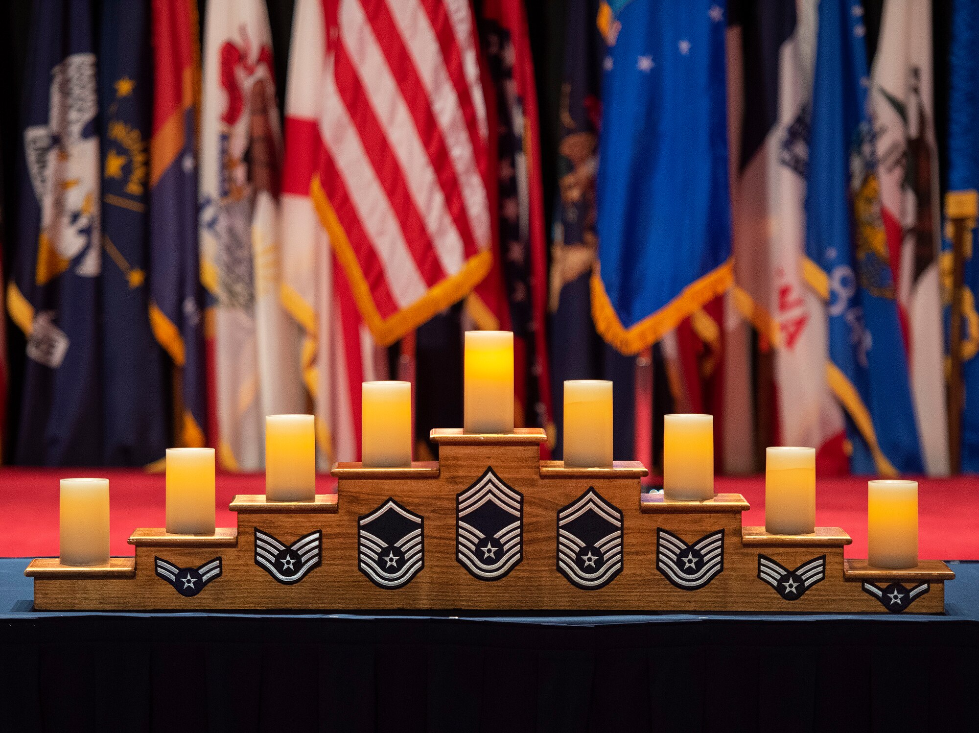 Candles representing the different enlisted ranks are placed on a candelabra May 14, 2022, during the Wright-Patterson Chief Master Sergeant Recognition Ceremony at the National Museum of the U.S. Air Force. The event honored the Wright-Patt Airmen recently selected for promotion to the Air Force’s highest enlisted rank. (U.S. Air Force photo by R.J. Oriez)