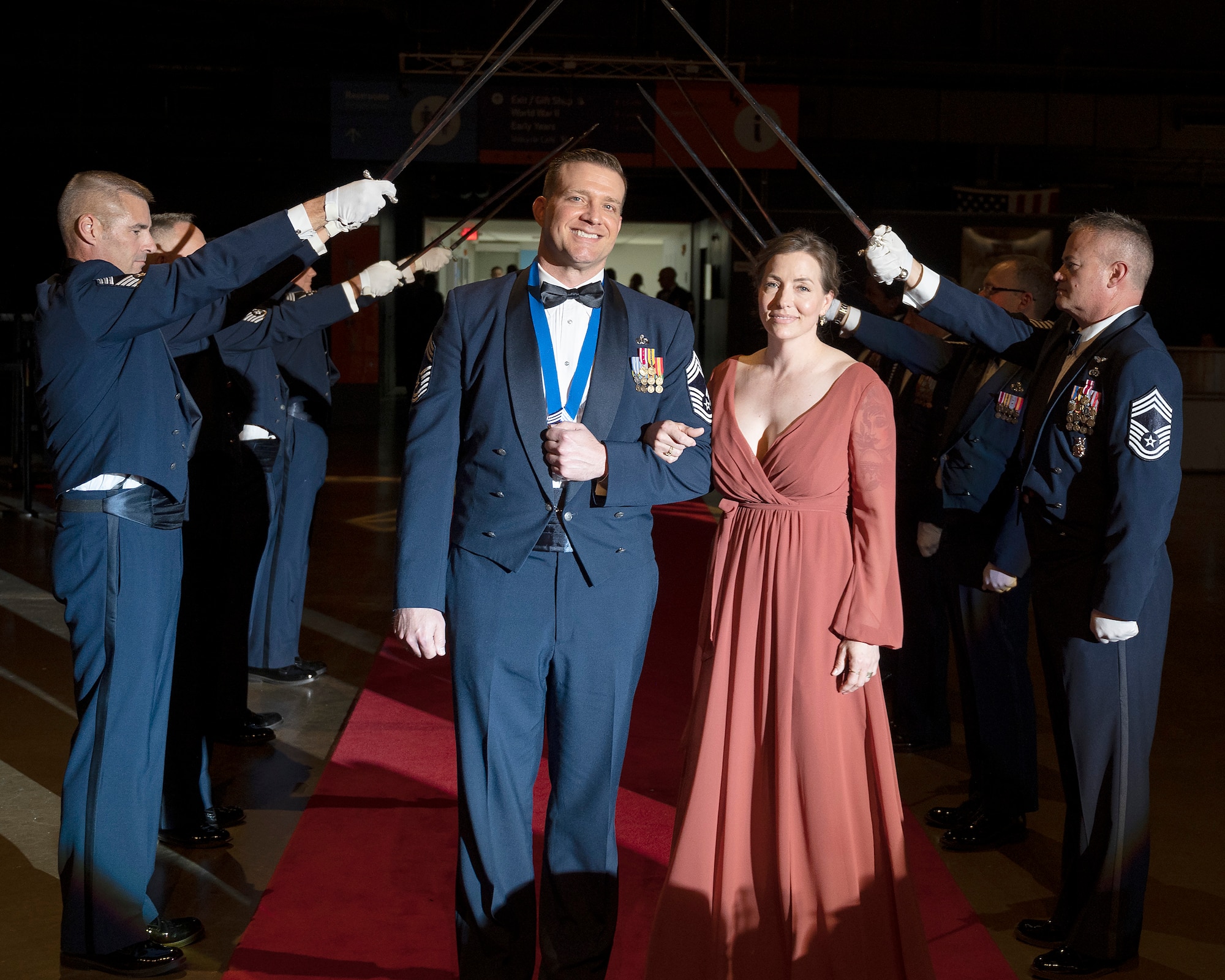 Chief Master Sgt. Kevin Cozad and his wife pass through the saber cordon May 14, 2022, as they enter the Wright-Patterson Chief Master Sergeant Recognition Ceremony at the National Museum of the U.S. Air Force. The event honored the Wright-Patt Airmen recently selected for promotion to the Air Force’s highest enlisted rank. (U.S. Air Force photo by R.J. Oriez)