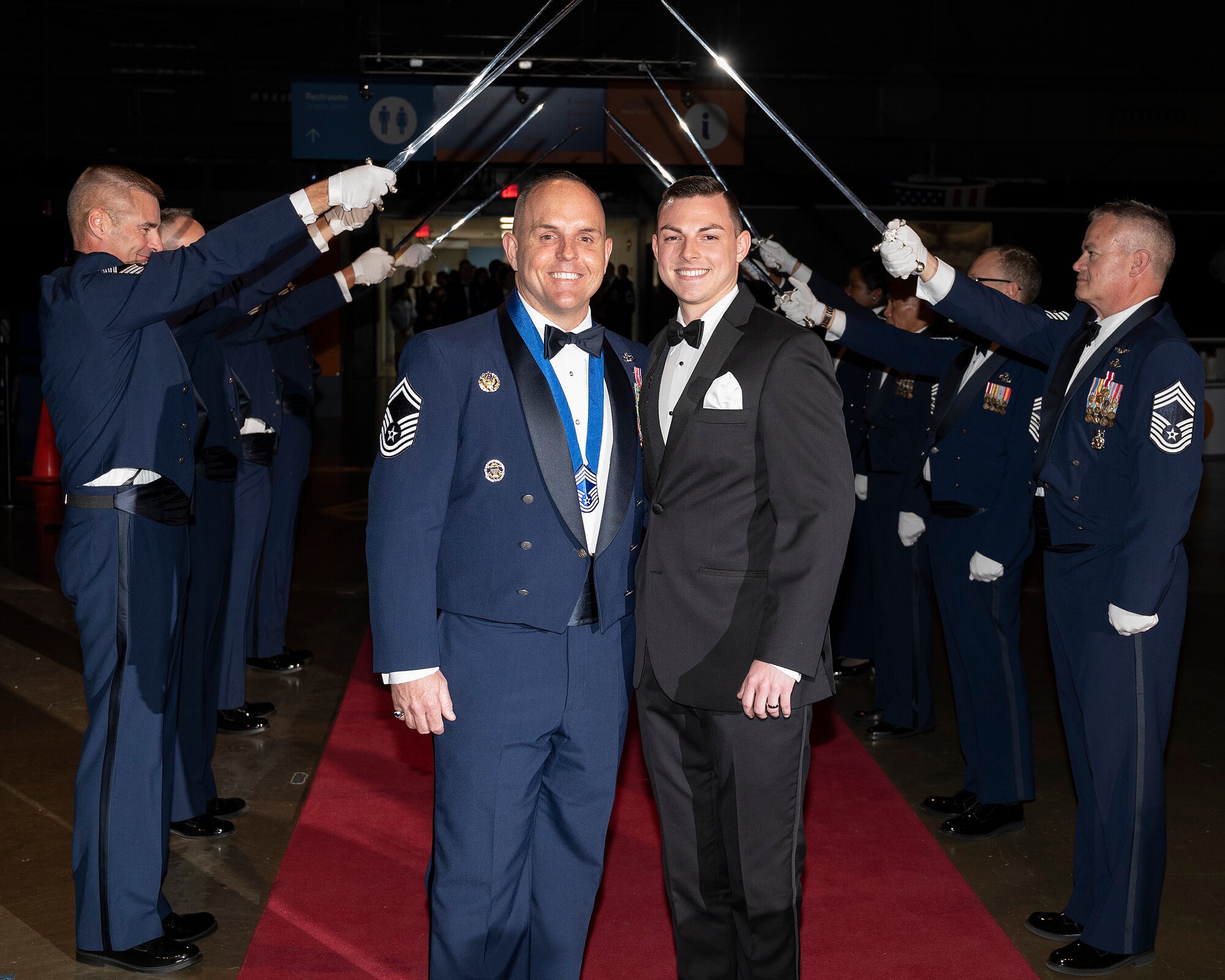 Senior Master Sgt. Chad Goff and his spouse pause after passing the saber cordon May 14, 2022, as they enter the Wright-Patterson Chief Master Sergeant Recognition Ceremony at the National Museum of the U.S. Air Force. The event honored the Wright-Patt Airmen recently selected for promotion to the Air Force’s highest enlisted rank. (U.S. Air Force photo by R.J. Oriez)