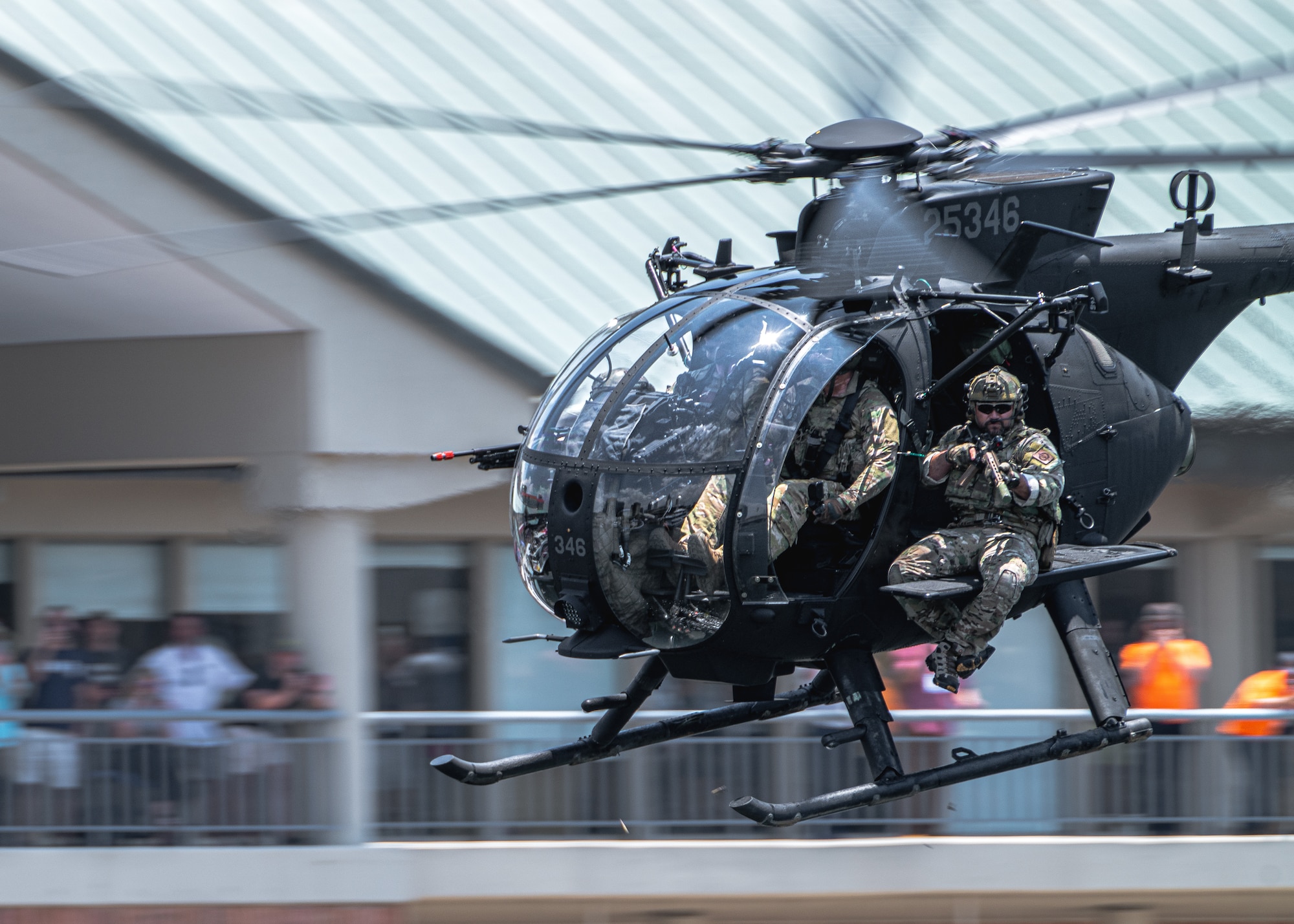 Members assigned to U.S. Special Operations Command fire blank rounds from a helicopter during a Special Operations Forces (SOF) demonstration in Downtown Tampa, Florida, May 18, 2022.