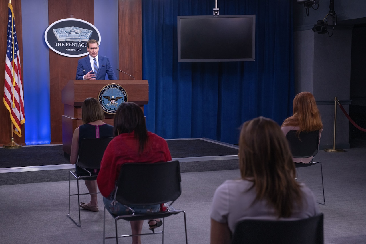 A  man speaks to a roomful of reporters.