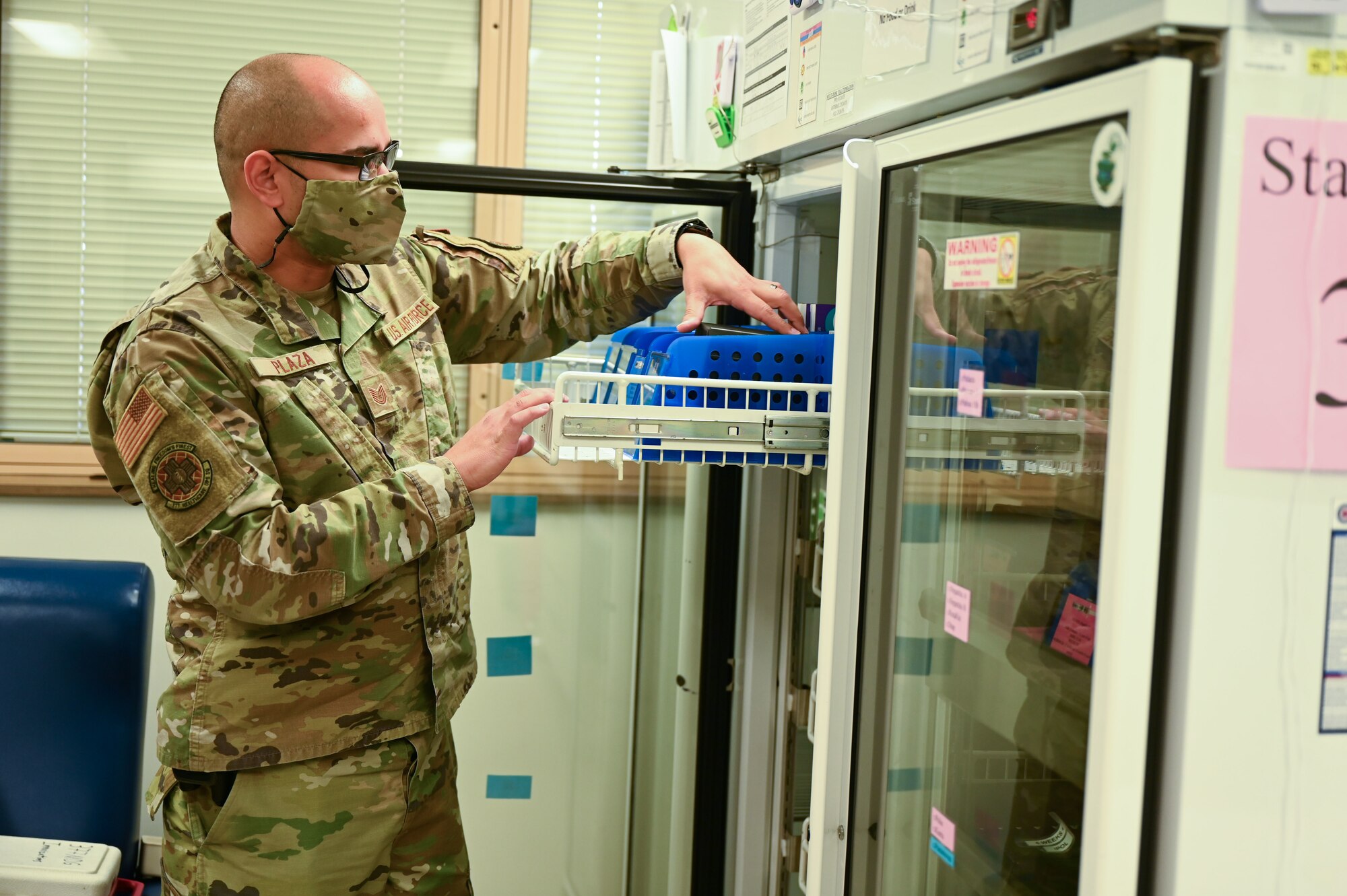 A man retrieves medicine from a refrigerator.