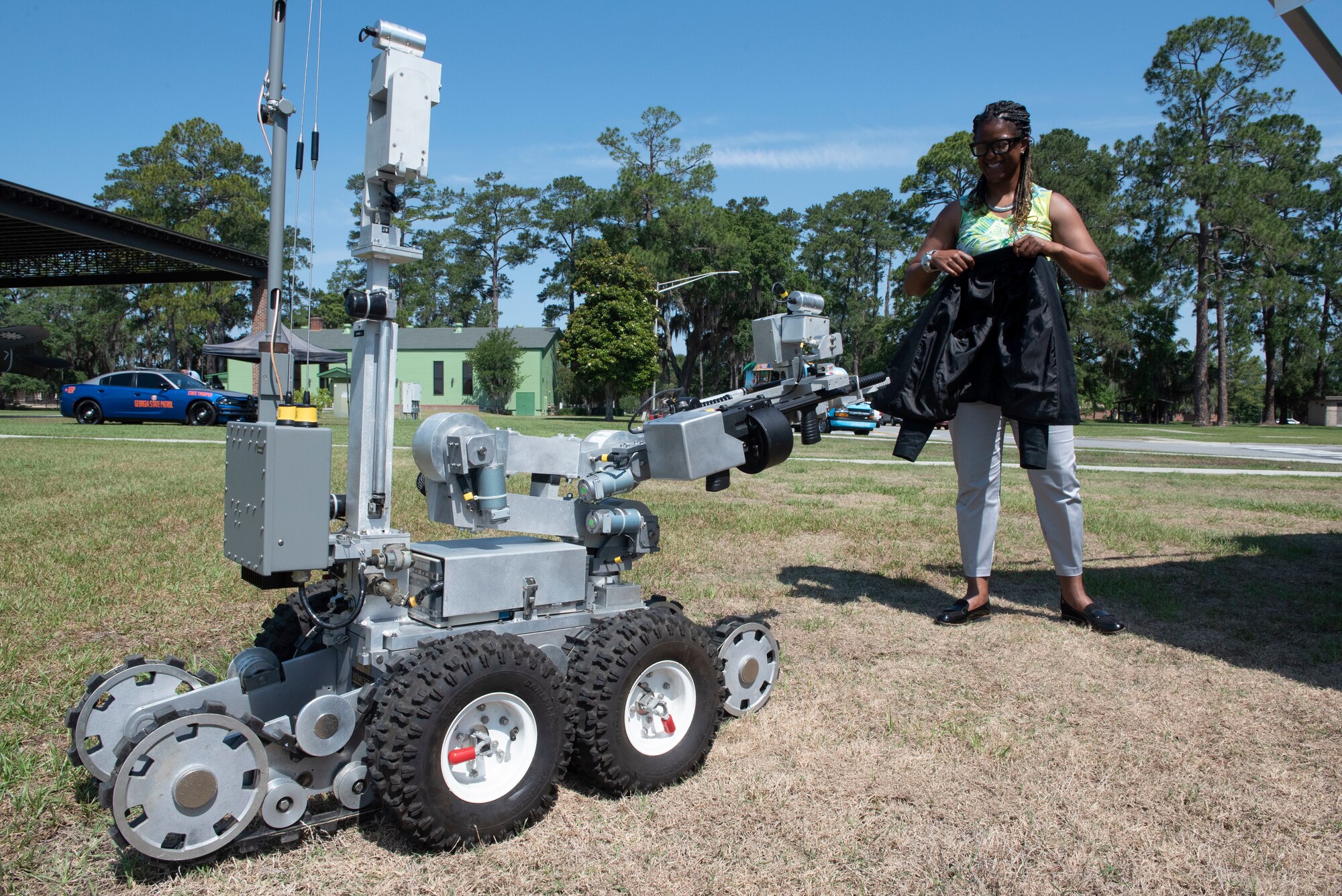 A Remotec Andros F-6B tactical robot hands a jacket to an observer during National Police Week at Moody Air Force Base, Georgia, May 17, 2022. The 23rd Security Forces Squadron stood up a law enforcement display to give Moody AFB personnel and their families an opportunity to learn about the tactics and equipment military and local law enforcement agencies employ. (U.S. Air Force photo by Staff Sgt. Thomas Johns)