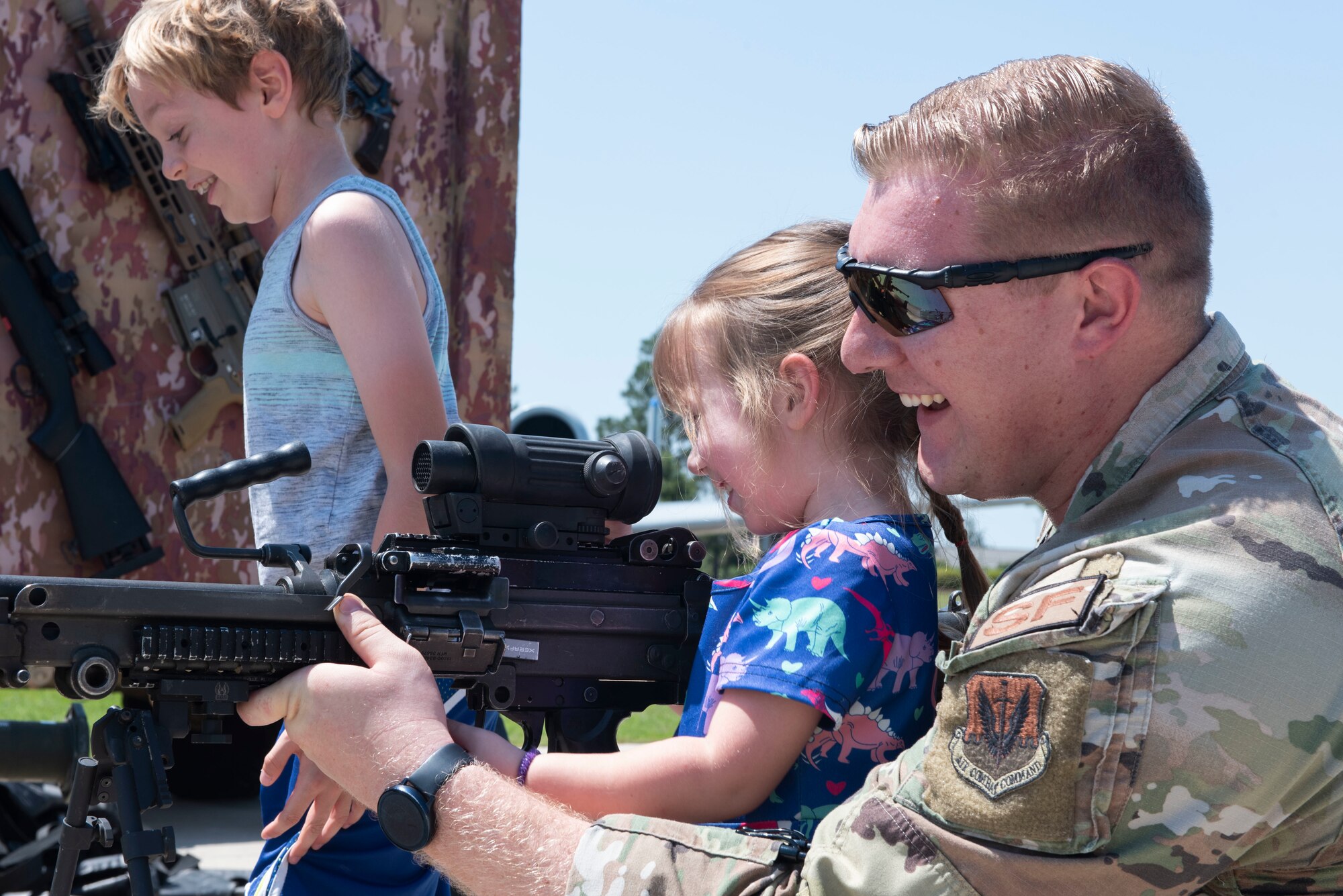 U.S. Air Force Staff Sgt. Kyle Jester, 23rd Security Forces Squadron patrolman, shows his daughter an M60 machine gun during a law enforcement display as part of National Police Week at Moody Air Force Base, Georgia, May 17, 2022. The law enforcement display gave Moody personnel and their families an opportunity to learn more about the tactics and equipment military and local law enforcement agencies employ. (U.S. Air Force photo by Staff Sgt. Thomas Johns)
