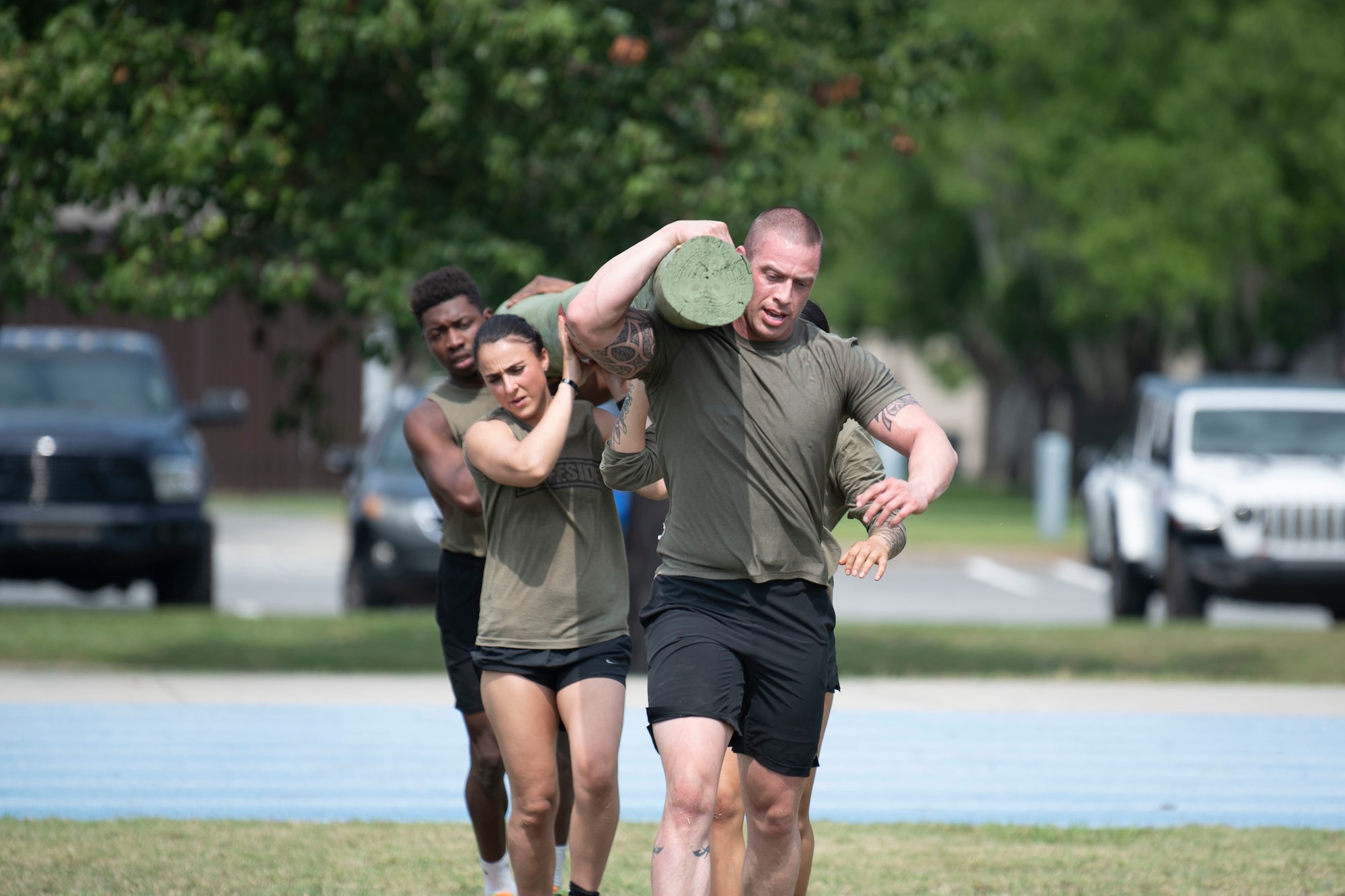 U.S. Air Force Airmen assigned to the 820th Base Defense Group carry a log during a fireteam gauntlet as part of National Police Week at Moody Air Force Base, Georgia, May 20, 2022. The relay race tested participants' physical strength as well as their ability to memorize a series of numbers while under pressure. (U.S. Air Force photo by Staff Sgt. Thomas Johns)