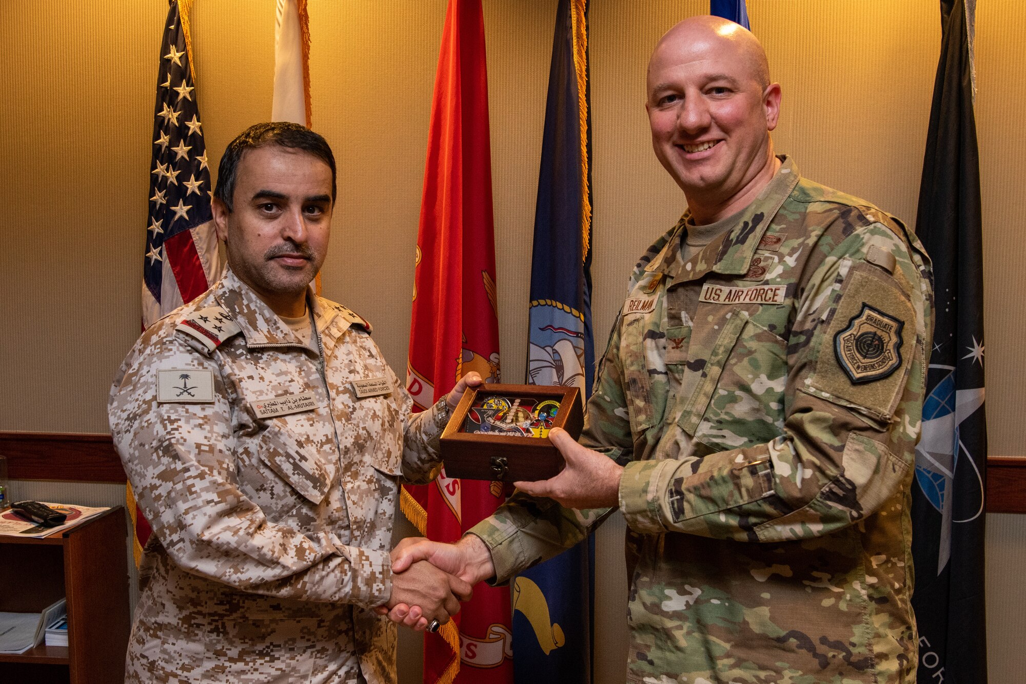 Royal Saudi Air Forces Commodore Al Mutairi Sattam Thaib, Armed Forces Intel and Security Institute commander, accepts a gift from U.S. Air Force Col. Matthew Reilman, 17th Training Wing commander, Goodfellow Air Force Base, May 18, 2022. Members of the RSAF visited Goodfellow AFB to learn about the joint and coalition forces intelligence, surveillance, and reconnaissance training provided by the 17th TRW.  (U.S. Air Force Photo by Senior Airman Michael Bowman)