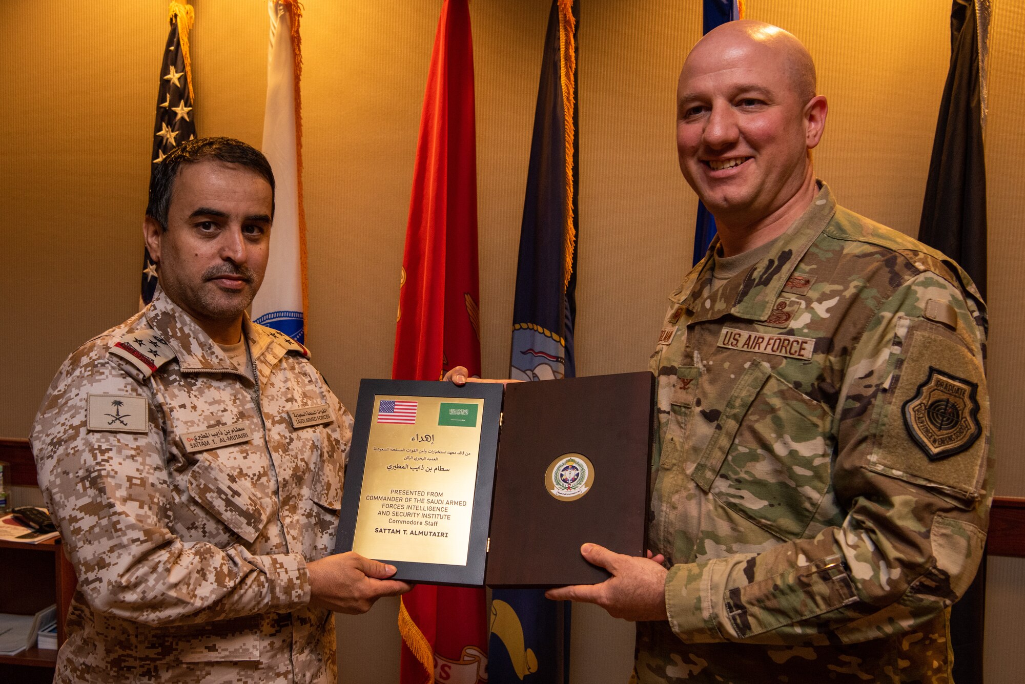Royal Saudi Air Forces Commodore Al Mutairi Sattam Thaib, Armed Forces Intel and Security Institute commander, presents a gift to U.S. Air Force Col. Matthew Reilman, 17th Training Wing commander, Goodfellow Air Force Base, May 18, 2022. Members of the RSAF visited Goodfellow AFB to learn about the joint and coalition forces intelligence, surveillance, and reconnaissance training provided by the 17th TRW. (U.S. Air Force Photo by Senior Airman Michael Bowman)