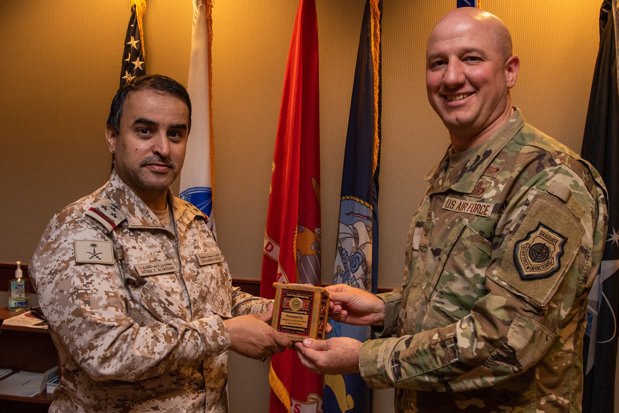 Royal Saudi Air Forces Commodore Al Mutairi Sattam Thaib, Armed Forces Intel and Security Institute commander, presents a gift to U.S. Air Force Col. Matthew Reilman, 17th Training Wing commander, Goodfellow Air Force Base, May 18, 2022. Members of the RSAF visited Goodfellow AFB to learn about the joint and coalition forces intelligence, surveillance, and reconnaissance training provided by the 17th TRW. (U.S. Air Force Photo by Senior Airman Michael Bowman)