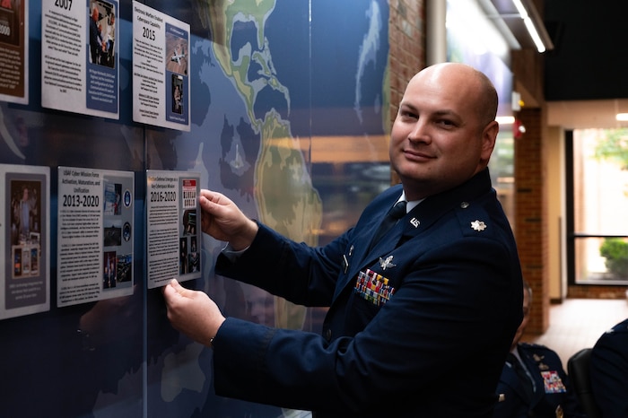 U.S. Air Force Lt. Col. Steven Payne, 837th Cyberspace Operations Squadron commander places the last tile during a timeline induction ceremony at HQ Cyberspace Capabilities Center on Scott Air Force Base, Illinois, May 19, 2022. The Timeline Tile Ceremony honored contributions towards the Air Force cyberspace and communication capabilities throughout history. (U.S. Air Force photo by Airman 1st Class Mark Sulaica)