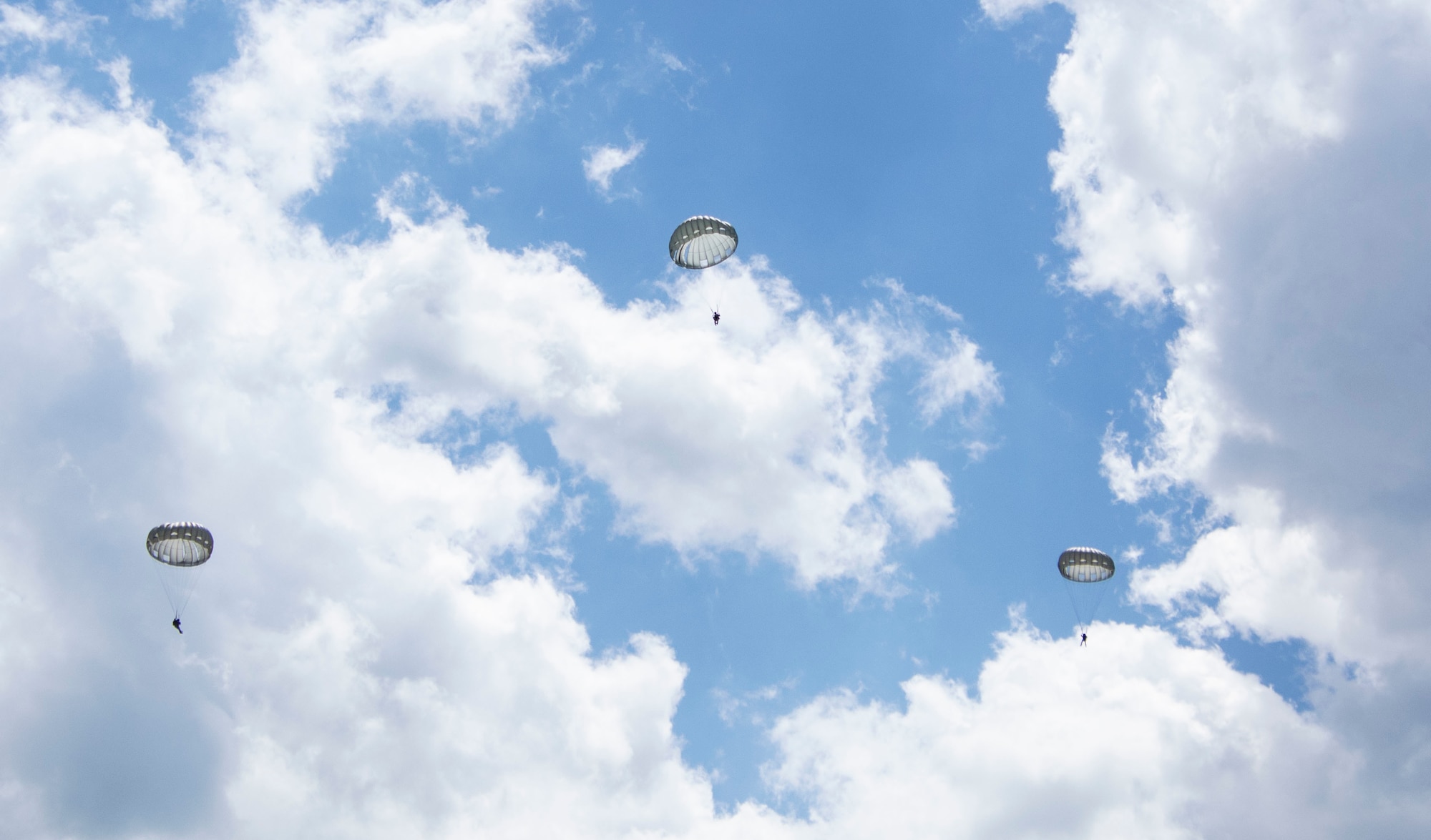 Three Airmen from the 14th Air Support Operations Squadron, United State Air Force, parachute over the a field at Fort Indiantown Gap, Pa. The airmen jumped from a Pennsylvania Army National Guard CH-47 Chinook during joint training on May 17, 2022.