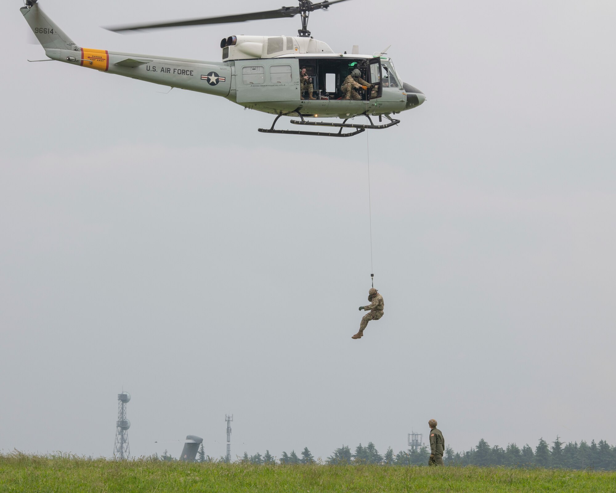 Staff Sgt. Zach Webster, 459th Airlift Squadron special missions aviator, is hoisted into a UH-1N Iroquois during Friendship Festival 2022, at Yokota Air Base, Japan, May 21. The demonstration was one of many events during the weekend that showcased U.S. military capabilities. (U.S. Air Force photo by Machiko Arita)