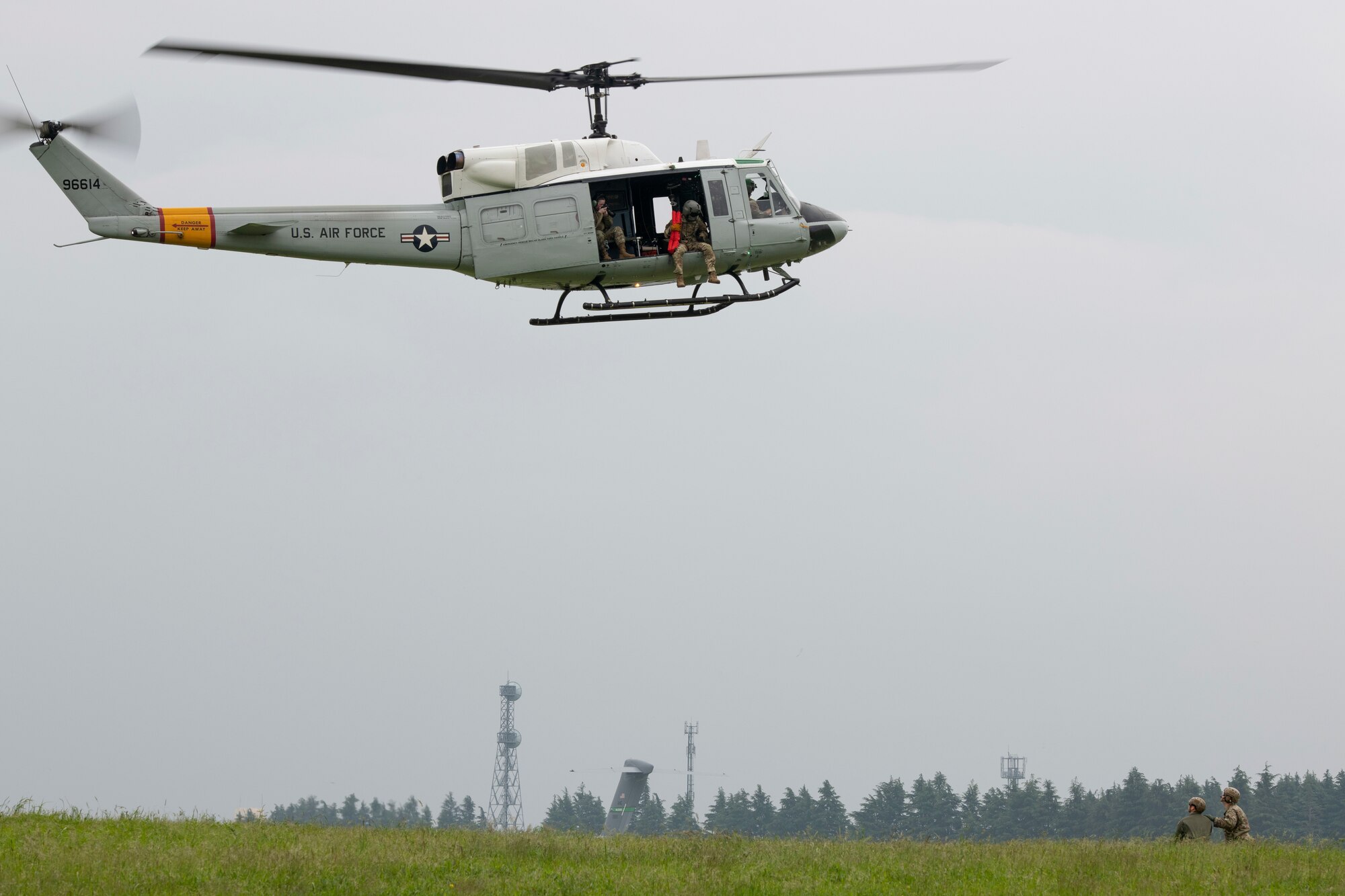 Staff Sgt. Zach Webster, 459th Airlift Squadron special missions aviator, prepares to be hoisted into a UH-1N Iroquois during Friendship Festival 2022, at Yokota Air Base, Japan, May 21. The demonstration was one of many events during the weekend that showcased U.S. military capabilities. (U.S. Air Force photo by Machiko Arita)