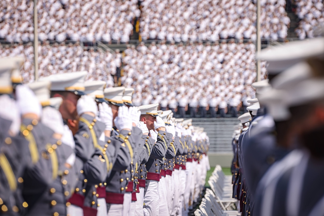 A group of cadets salute in formation.