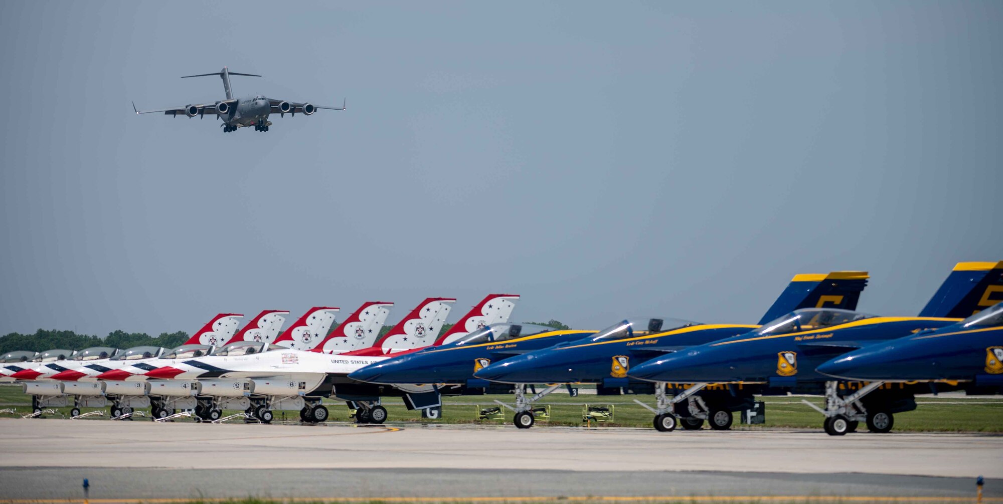 A U.S. Air Force C-17 Globemaster III flies over the U.S. Navy Blue Angels and the U.S. Air Force Thunderbirds, during the first day of the 2022 Thunder Over Dover Airshow, May 21, 2022, at Dover Air Force Base, Delaware. The airshow’s theme was “Reunite,” in celebration of people coming together after the COVID-19 pandemic. (U.S. Air Force photo by Senior Airman Faith Schaefer)