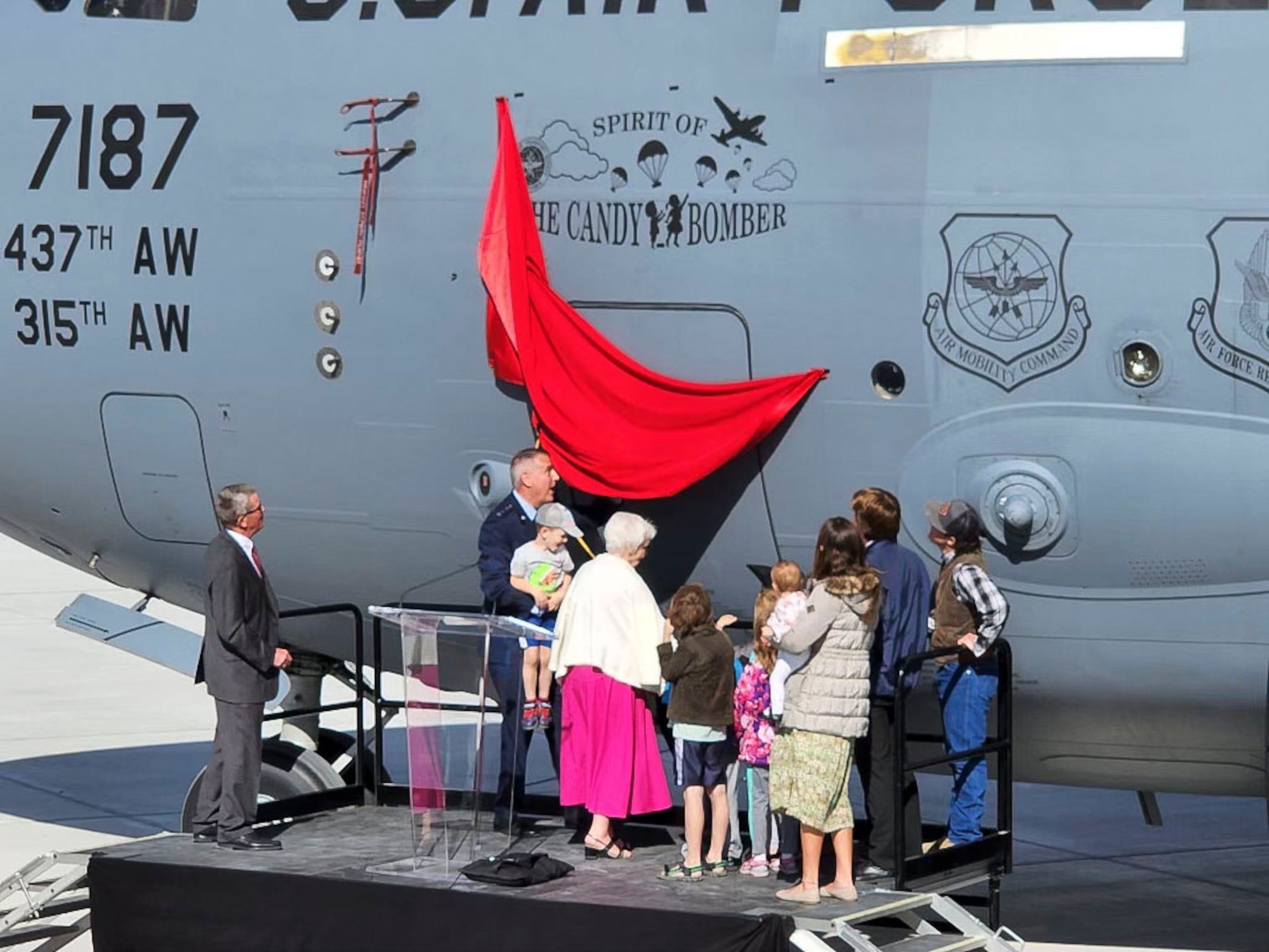 U.S. Air Force Gen Mike Minihan, Air Mobility Command commander, along with Col Gail Halvorsen's family members unveil the renaming of a C-17 Globemaster III to "Spirit of the Candy Bomber" in Provo, Utah, May 20, 2022.