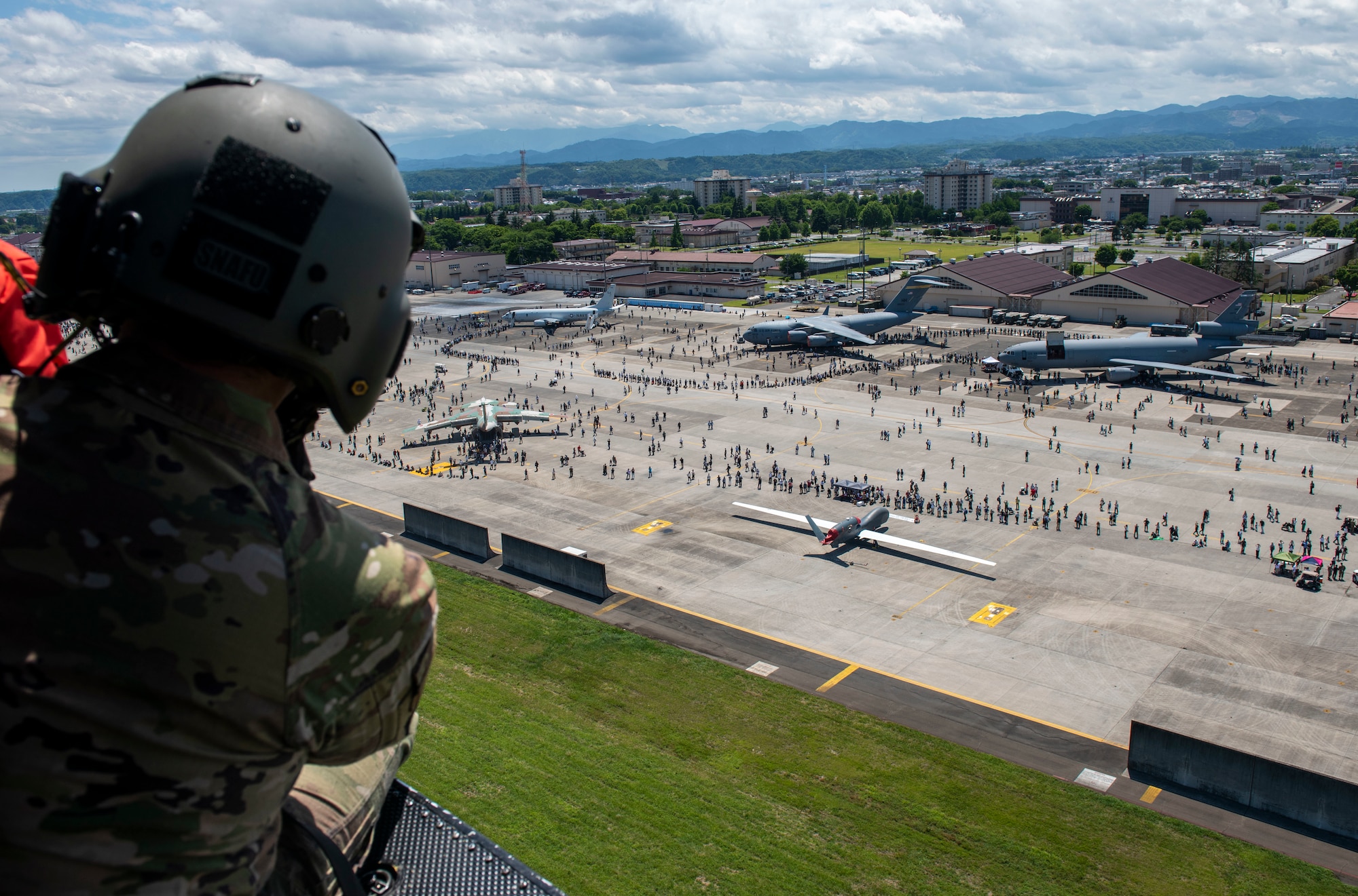 Tech. Sgt. Kevin Bell, 459th Airlift Squadron flight engineer, looks over a crowd of attendees watching a UH-1N Huey hoist demonstration during Friendship Festival 2022, at Yokota Air Base, Japan May 22, 2022. The two-day festival was an opportunity for visitors to learn more about the U.S. and Japan bilateral partnership, while strengthening the bonds between Yokota and the local communities. Yokota was able to host the event with the support of Japanese Self-Defense Force, sister services and the local community. (U.S. Air Force photo by Senior Airman Hannah Bean)