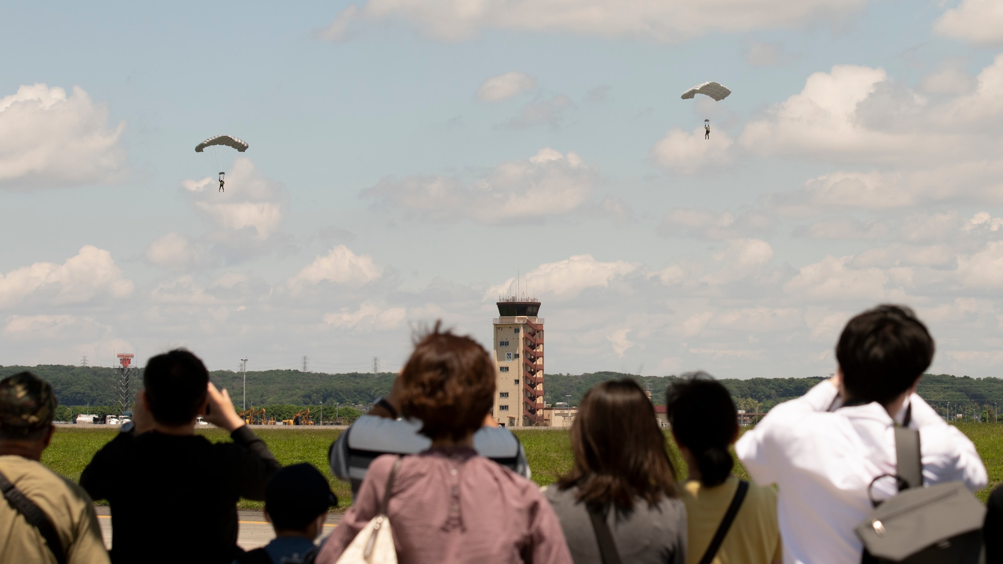 Paratroopers come in for a landing near the flight line after jumping from a C-130J Super Hercules during the Friendship Festival 2022, at Yokota Air Base, Japan, May 22, 2022. The two-day festival was an opportunity for visitors to learn more about the U.S. and Japan bilateral partnership, while strengthening the bonds between Yokota and the local communities. Yokota was able to host the event with the support of Japanese Self-Defense Force, sister services and the local community. (U.S. Air Force photo by Staff Sgt. Ryan Lackey)