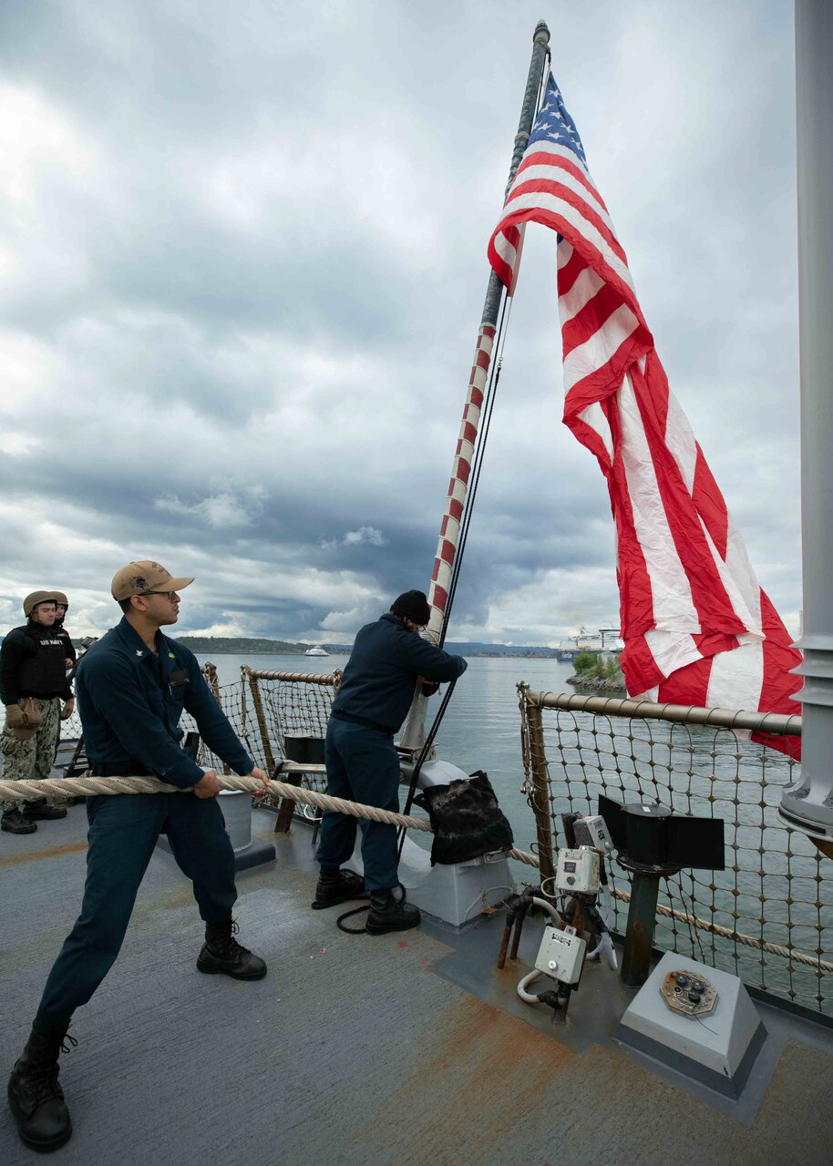 Fire Controlman (Aegis) 3rd Class Joseph Rangel, left, and Fire Controlman (Aegis) 3rd Class Nicole Farrell, right, hoist up the ensign aboard the Arleigh Burke-class guided-missile destroyer USS Porter (DDG 78), while arriving at Oslo for a scheduled port visit, May 22, 2022. Porter is on a scheduled deployment in the U.S. Naval Forces Europe area of operations, employed by U.S. Sixth Fleet to defend U.S., Allied and Partner interests.