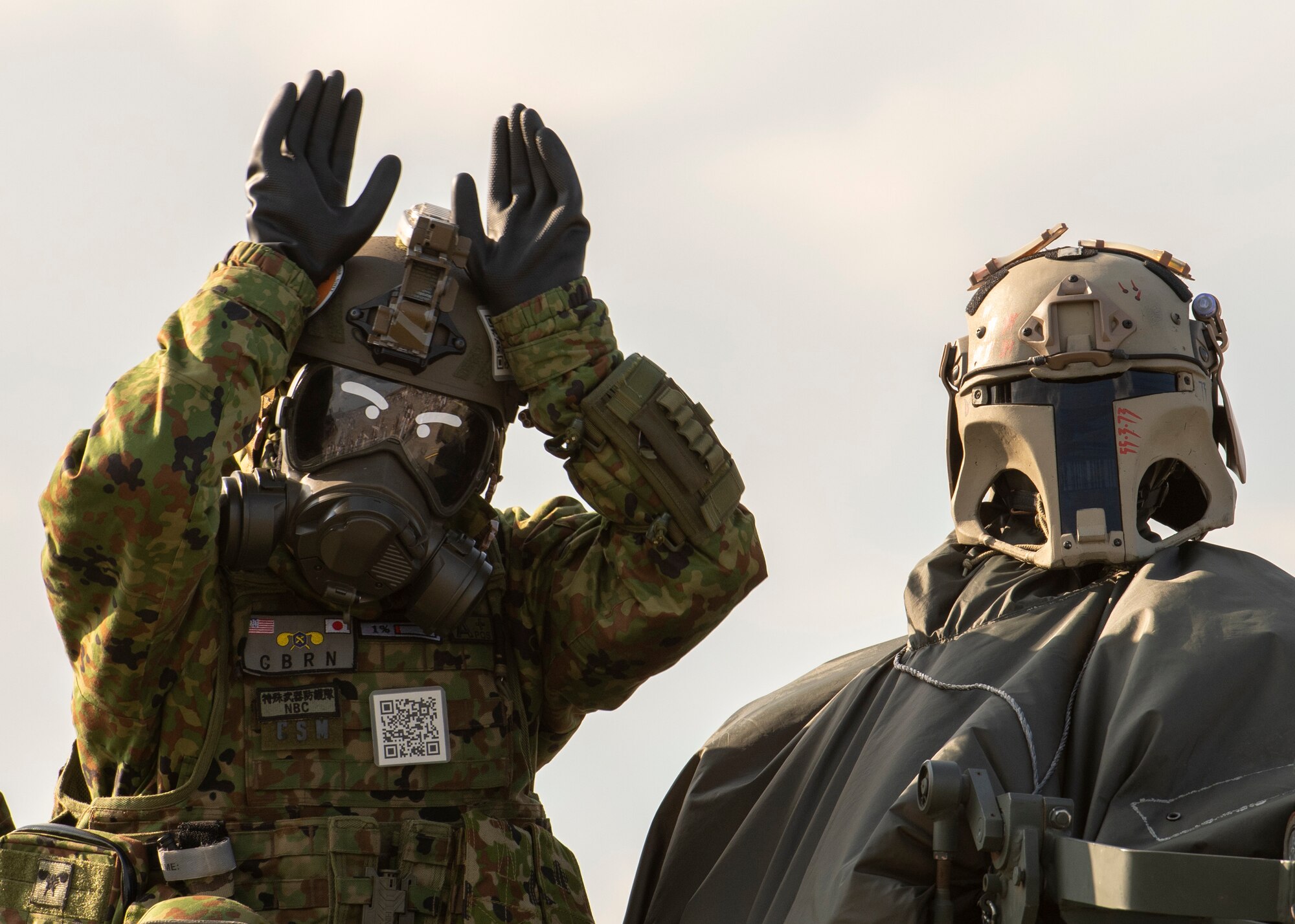 A Japan Ground Self Defense Force member in protective gear gestures to the crowd from atop and armored personnel carrier during Friendship Festival 2022, at Yokota Air Base, Japan, May 22, 2022. The two-day festival was an opportunity for visitors to learn more about the U.S. and Japan bilateral partnership, while strengthening the bonds between Yokota and the local communities. Yokota was able to host the event with the support of Japan Self-Defense Force, sister services and the local community. (U.S. Air Force photo by Staff Sgt. Ryan Lackey)