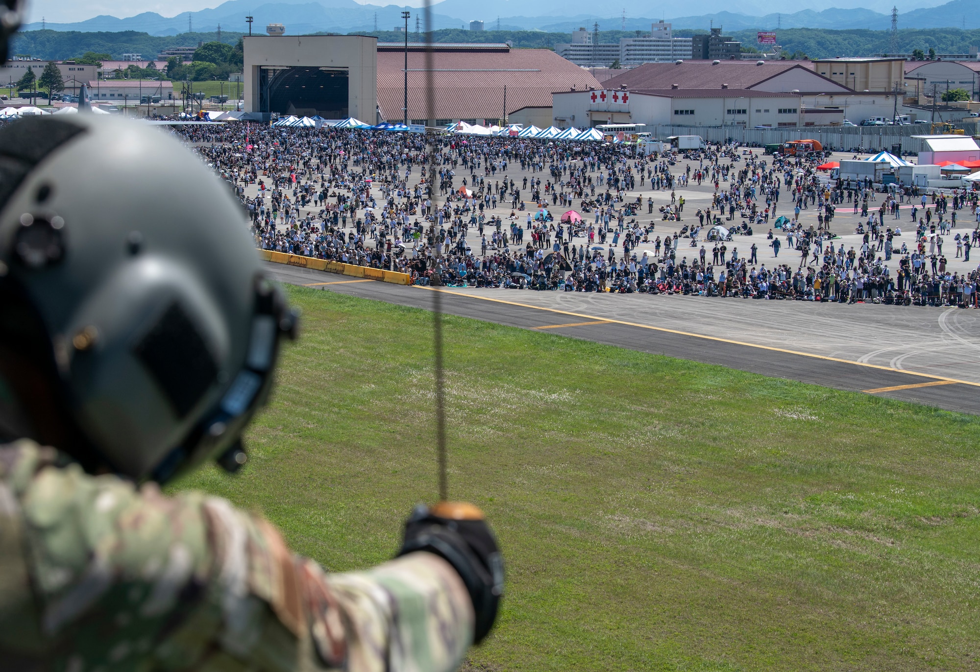 Attendees watch as Tech. Sgt. Kevin Bell, 459th Airlift Squadron flight engineer, guides a hoist during Friendship Festival 2022, at Yokota Air Base, Japan May 22, 2022. The two-day festival was an opportunity for visitors to learn more about the U.S. and Japan bilateral partnership, while strengthening the bonds between Yokota and the local communities. Yokota was able to host the event with the support of Japan Self-Defense Force, sister services and the local community. (U.S. Air Force photo by Senior Airman Hannah Bean)