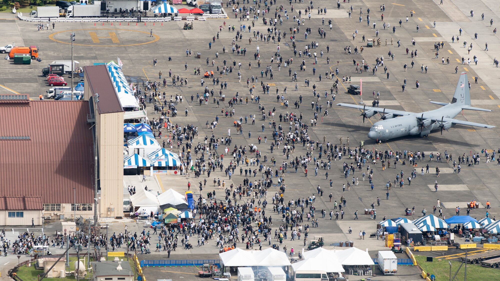Aerial view of a crowd spreading out onto a flight line