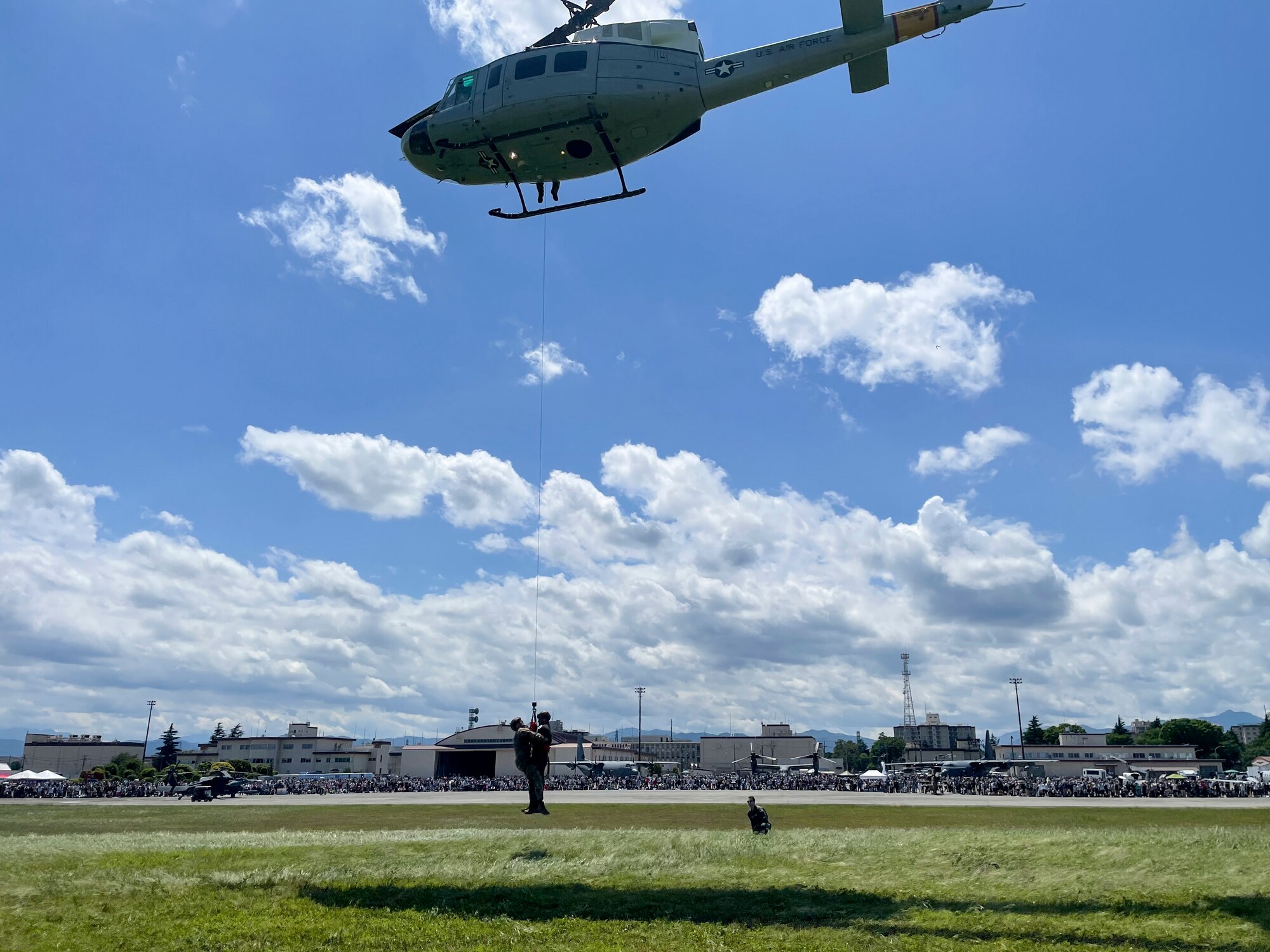 Two men are hoisted up into a hovering helicopter