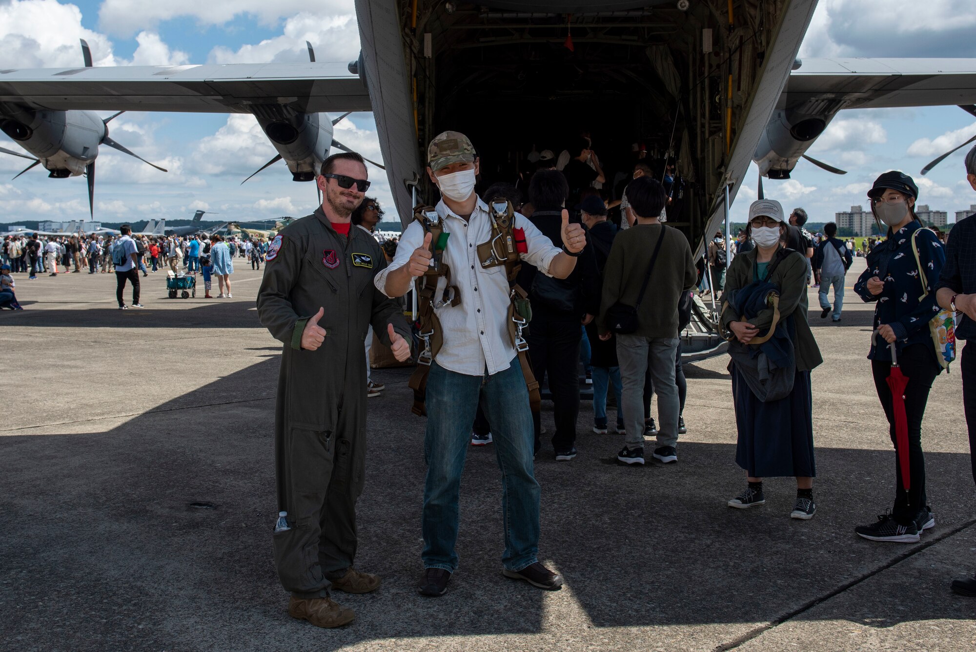 A U.S. Air Force Airman gives a thumps up pose with an attendee
