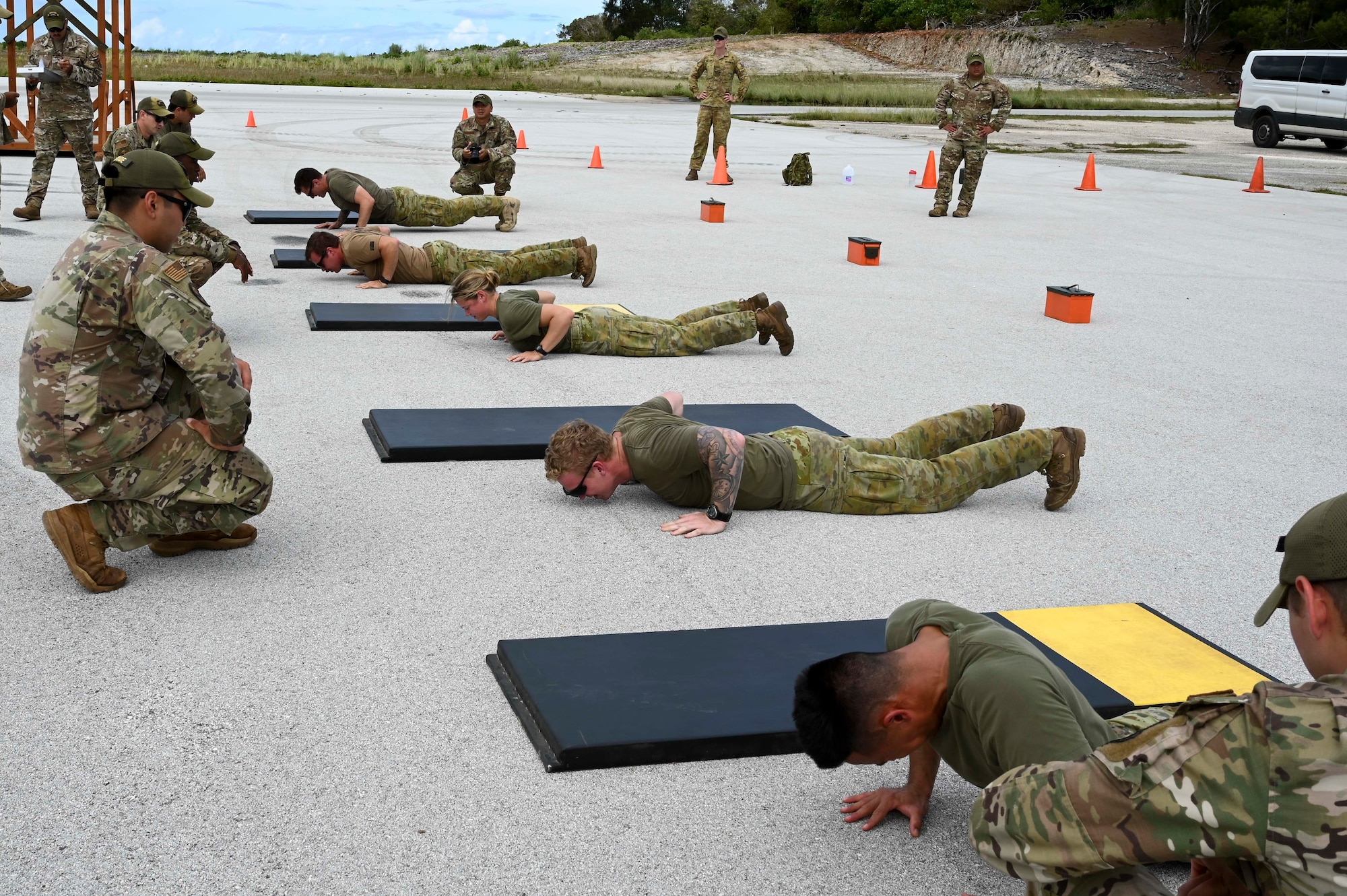 Members of the Royal Australian Air Force, 1st Security Forces Squadron, perform hand-release push-ups during the Advanced Combat Skills Assessment at Andersen Air Force Base, Guam April 16, 2022. ACSA is an annual training event designed to test the physical endurance and core operational skills of Pacific Air Force security forces and selected partner nations. (U.S. Air Force photo by Airman 1st Class Emily Saxton)