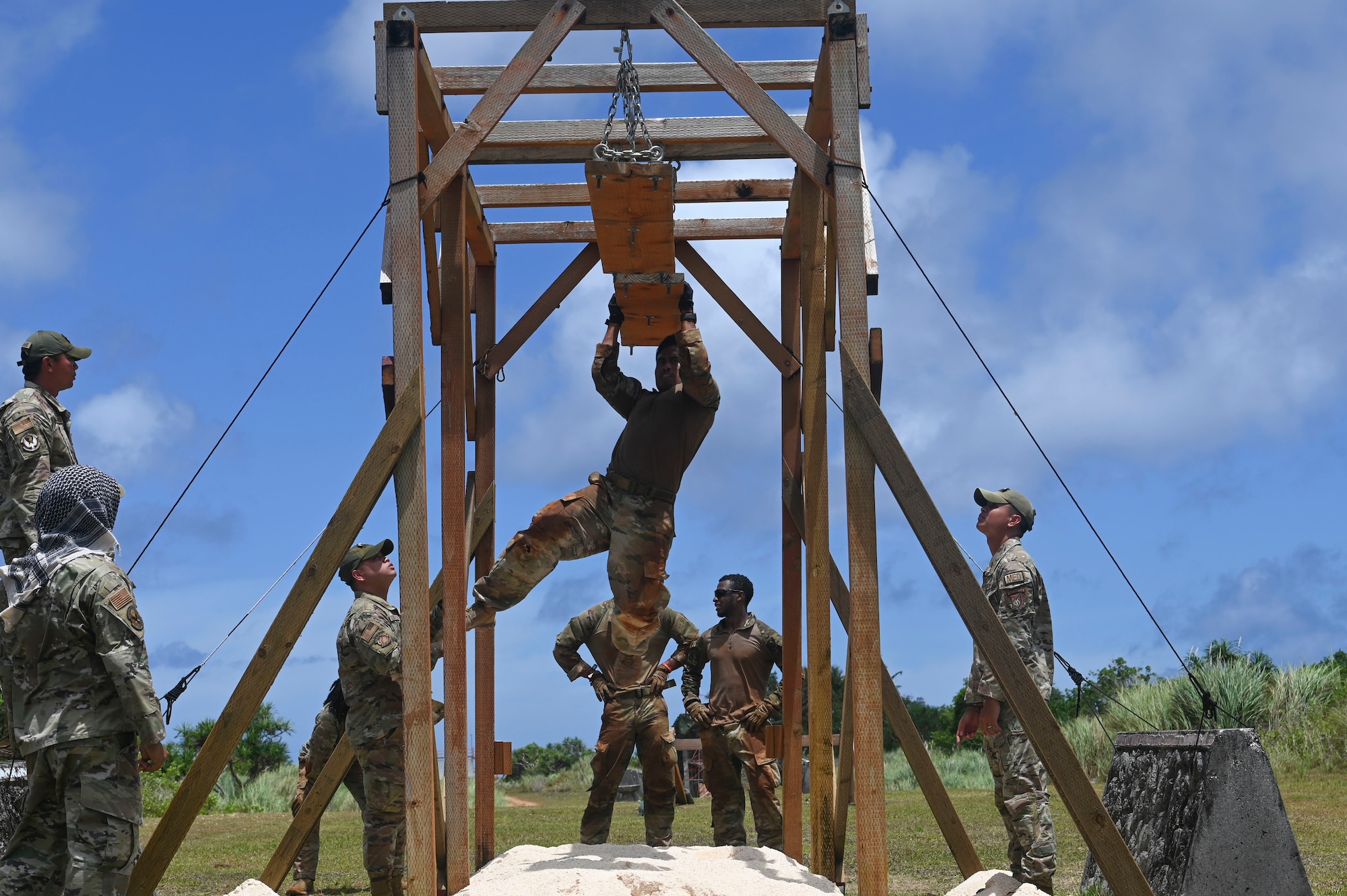 U.S. Air Force Tech. Sgt. Crisdaniel Medina assigned to the 647th Security Forces Squadron, Joint Base Pearl Harbor-Hickam, Hawaii, hangs from an obstacle during the Advanced Combat Skills Assessment at Andersen Air Force Base, Guam, April 17, 2022. ACSA is a week-long competition that showcases the combat capability of security forces as a human weapon system. (U.S. Air Force photo by Airman 1st Class Emily Saxton)
