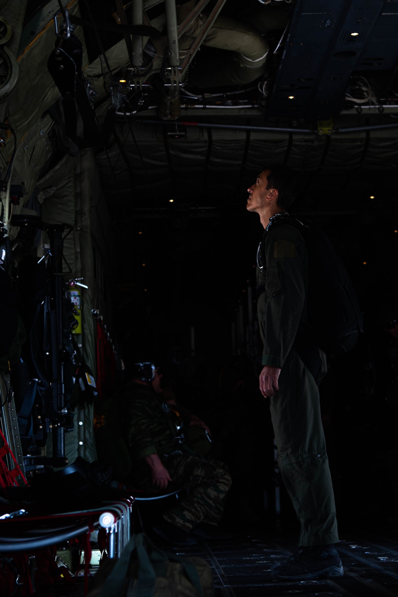 A service member looks up in an aircraft.
