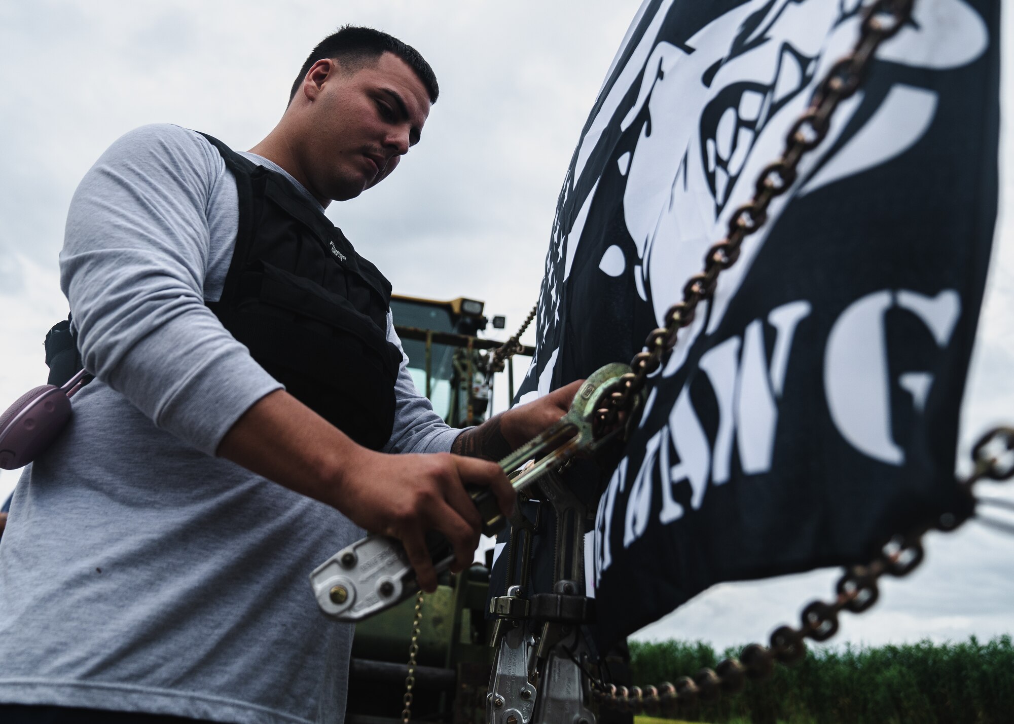 U.S. Air Force Airman 1st Class Rafael Rosado, 6th Logistics Readiness Squadron passenger terminal agent, fastens a device to a unit flag before the Port Dawg Memorial Run at MacDill Air Force Base, Florida, May 20, 2022.