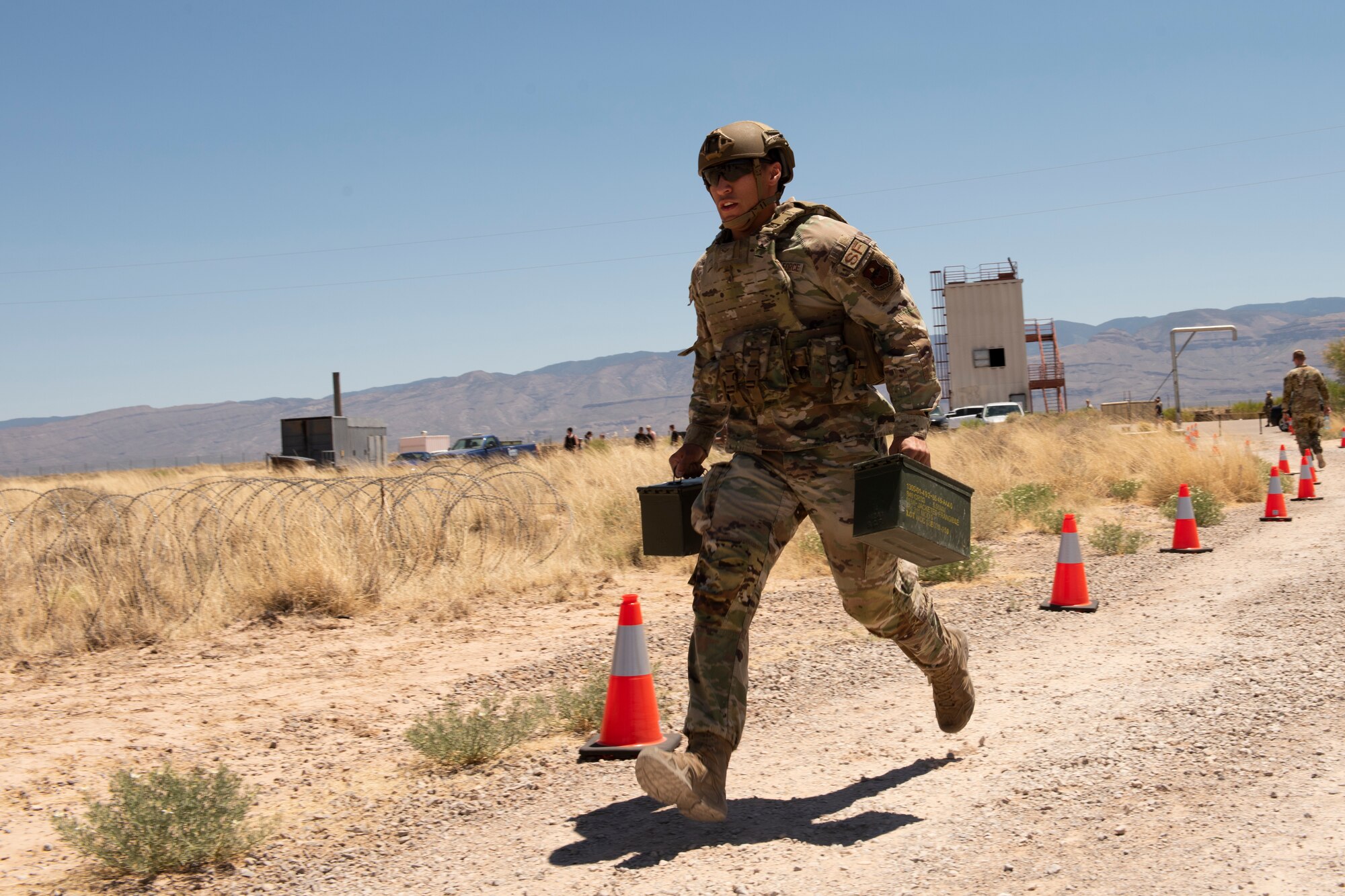 Airman 1st Class Kameron Dagahpat, 49th Security Forces Squadron member, runs with two ammo canisters during the Defender Challenge at the Security Forces Training Complex May 11, 2022, on Holloman Air Force Base, New Mexico. The challenge provided Defenders and other members of Team Holloman with a friendly competition to not only test security procedure knowledge but also further understand the complexities and variety of responsibilities held by security forces Airmen. (U.S. Air Force photo by Airman Isaiah Pedrazzini)